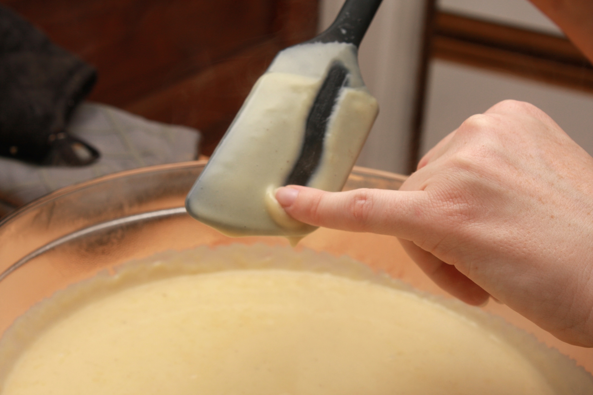 Alyssa runs a finger through the custard to make sure it is cooked through