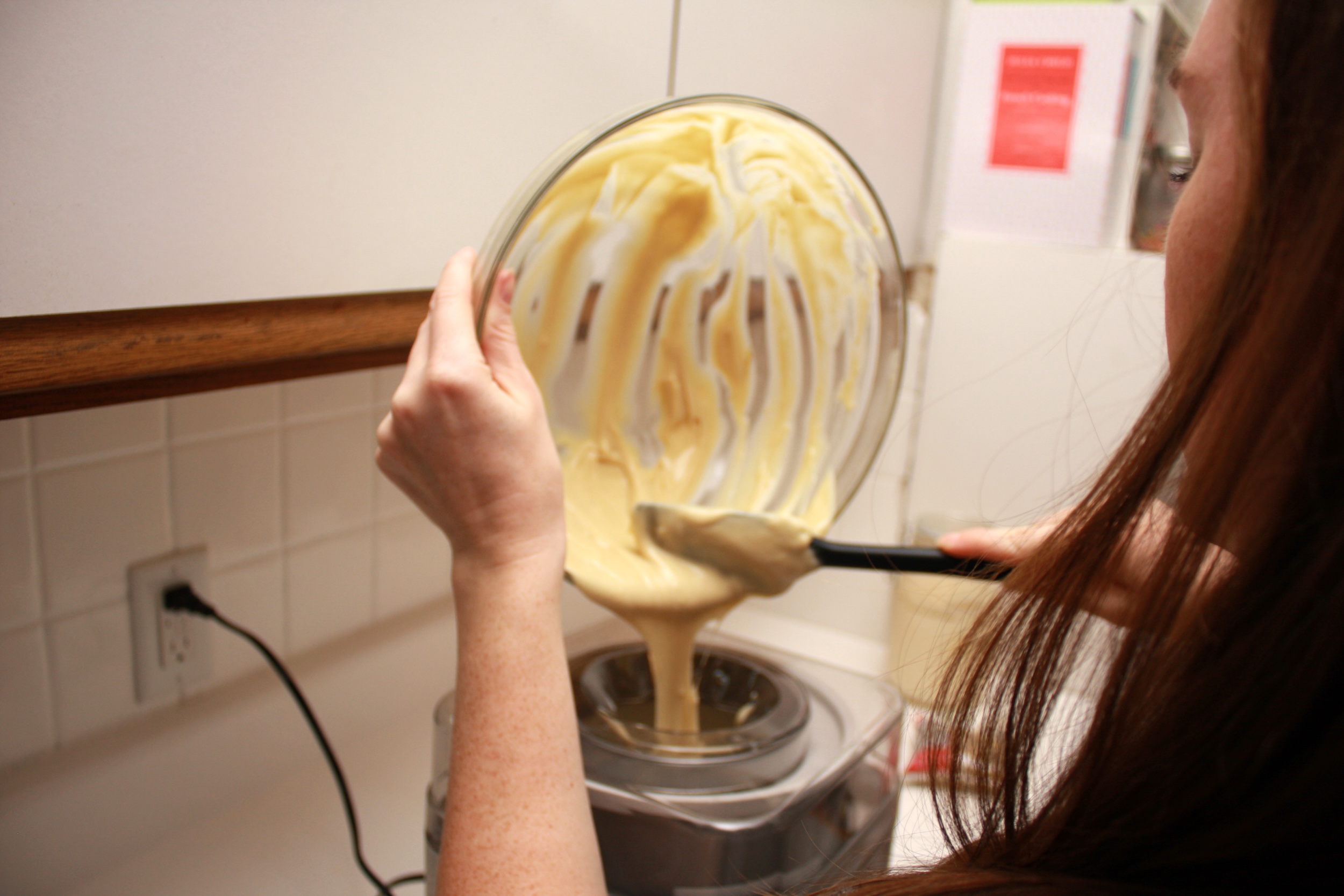 Alyssa scrapes the ice cream base from the bowl