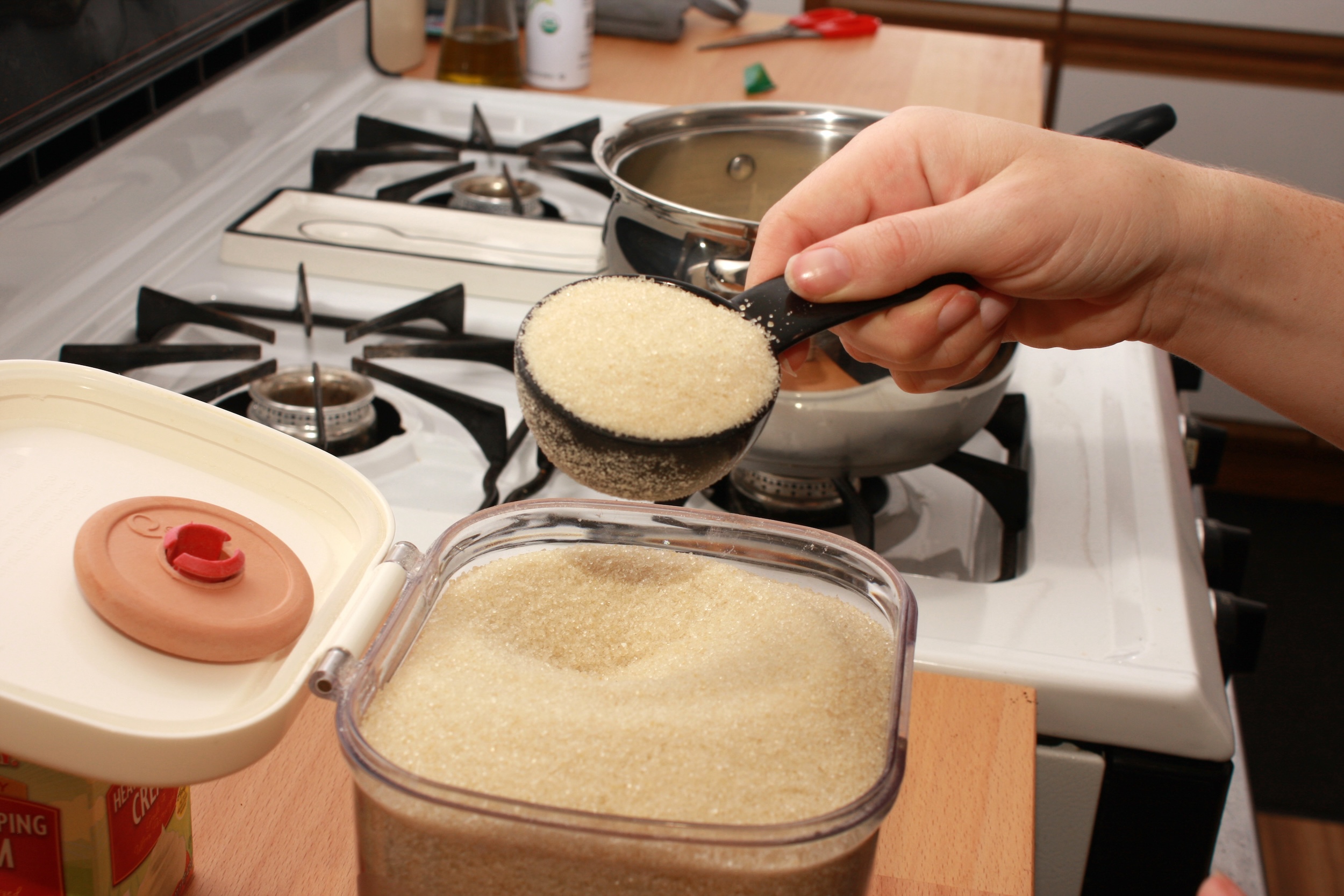 A hand measures sugar