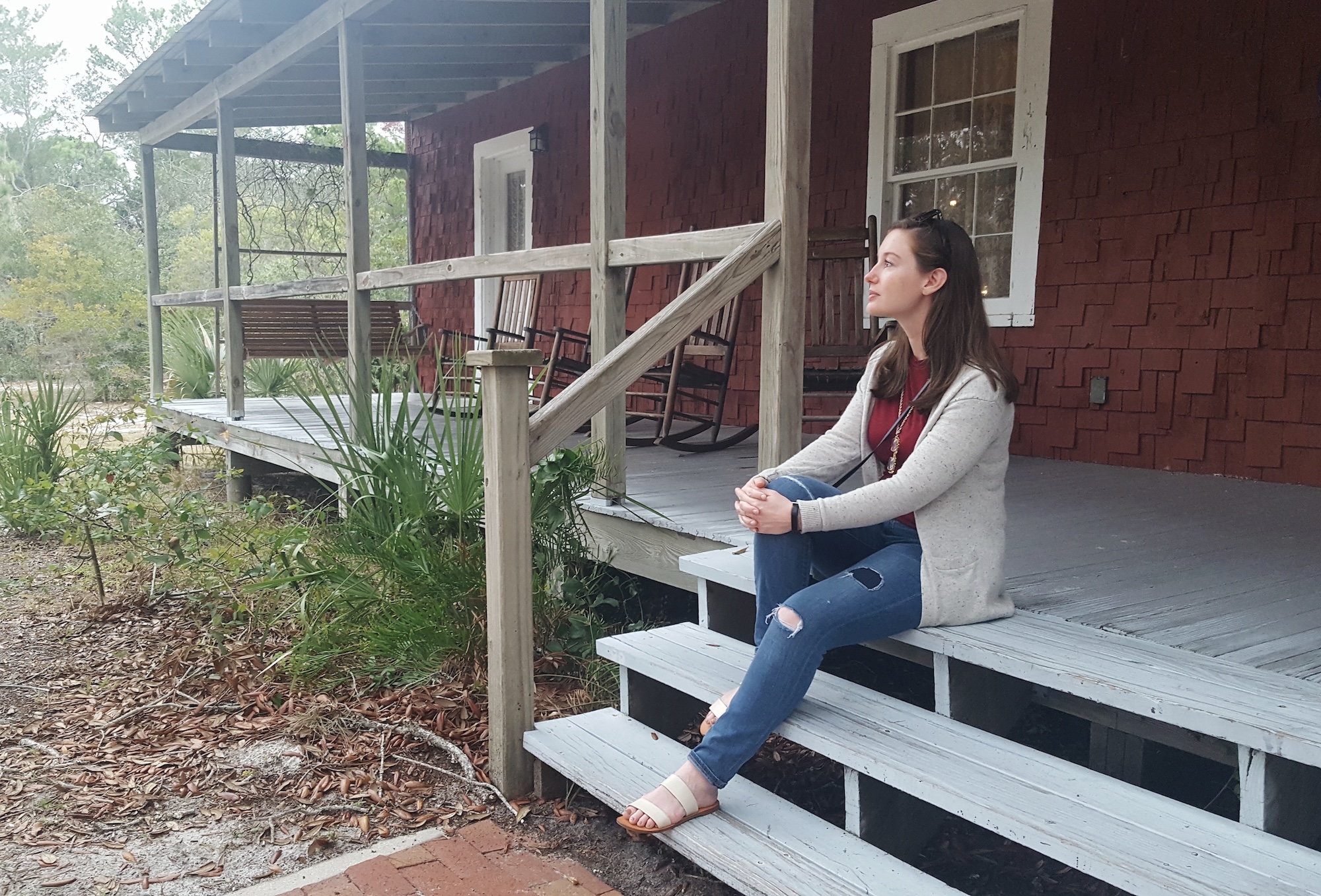 Alyssa sits on the porch at the Whitman house