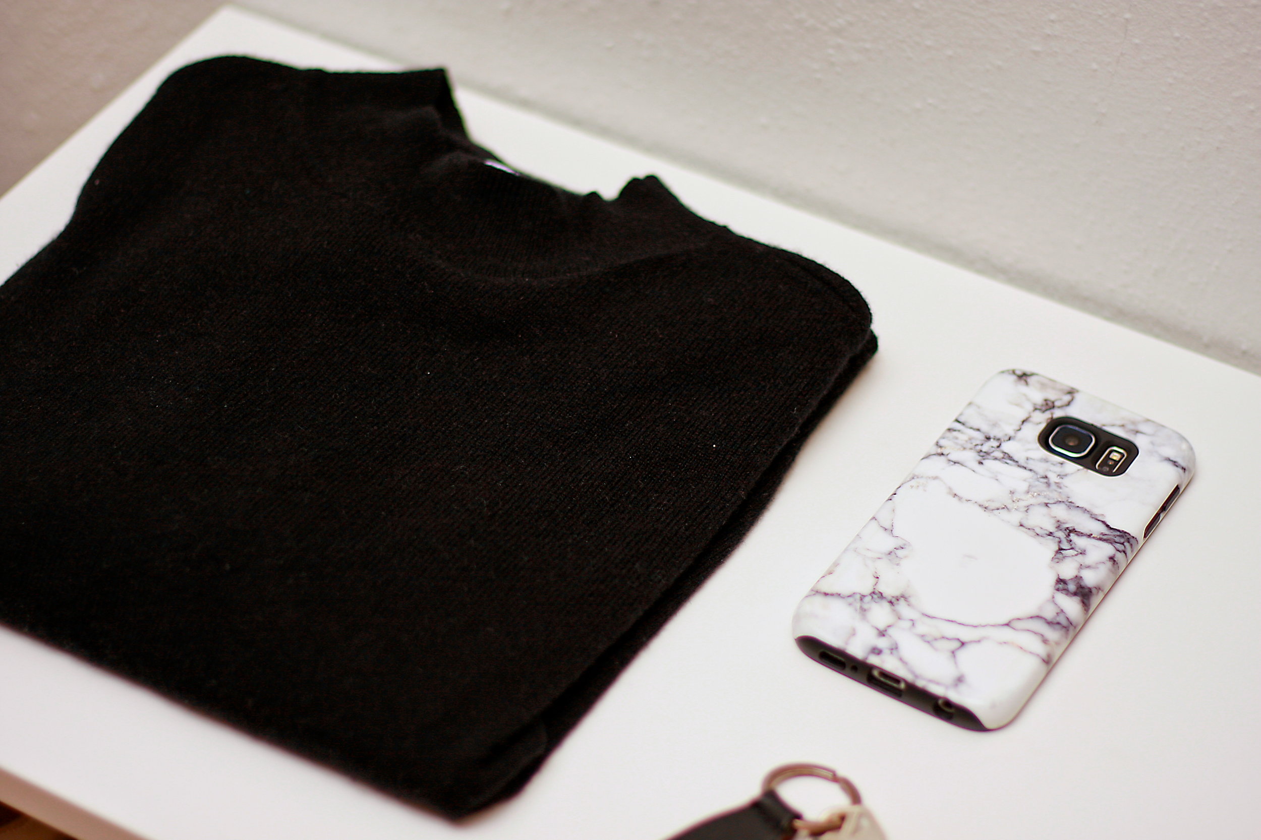 An Everlane Cashmere sweater sits on a white table