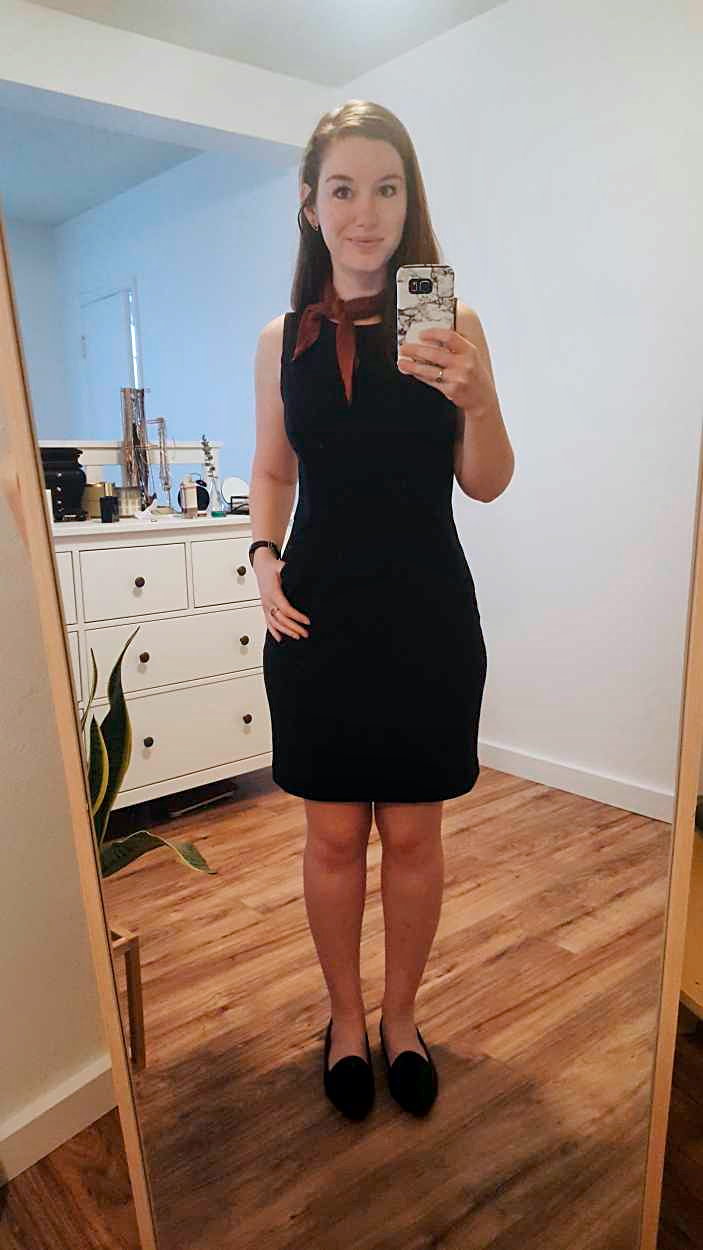 Alyssa wears a black sheath dress with black flats and a rust bandana in the morning