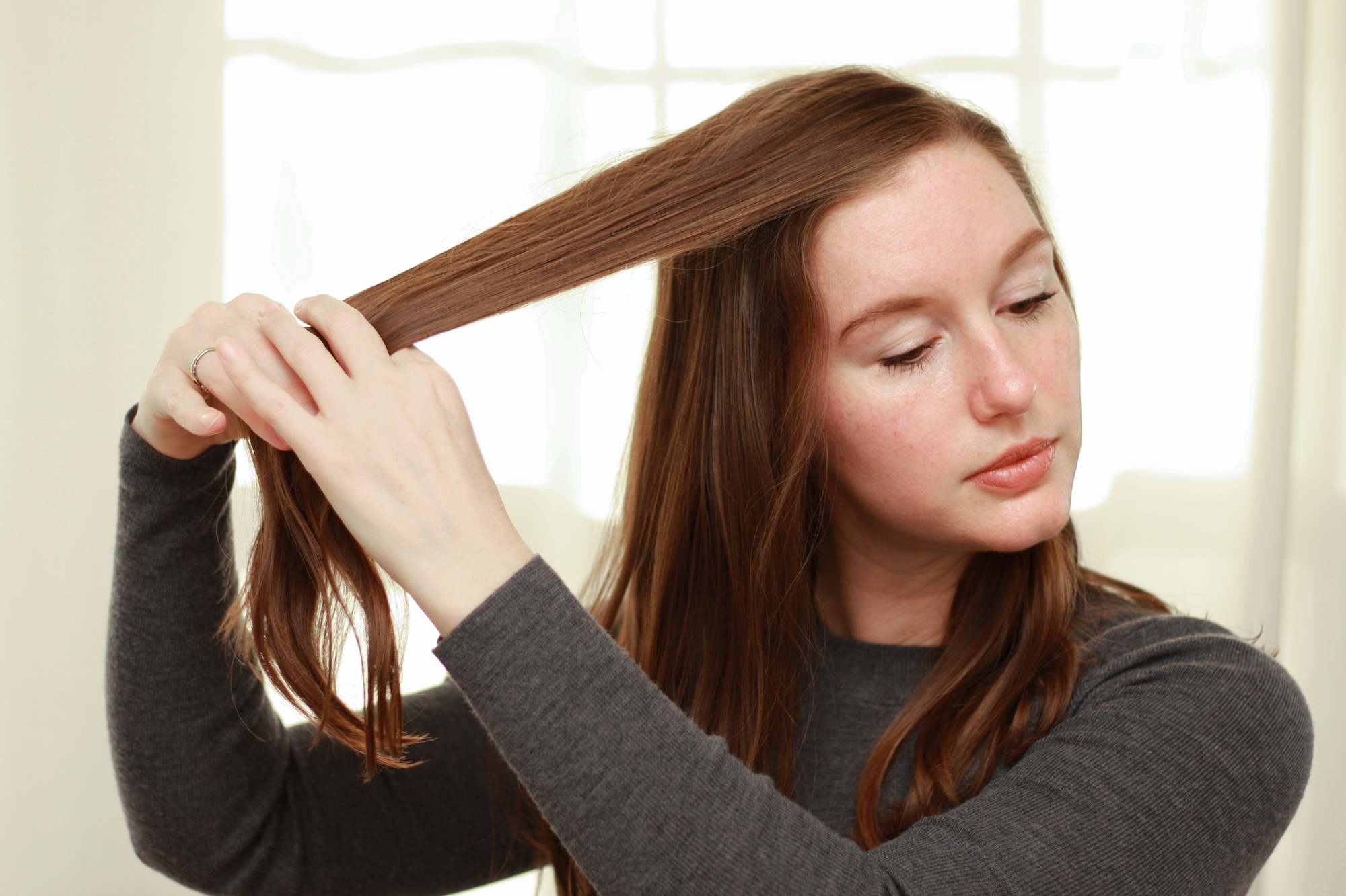 Alyssa adjusts the part of her hair