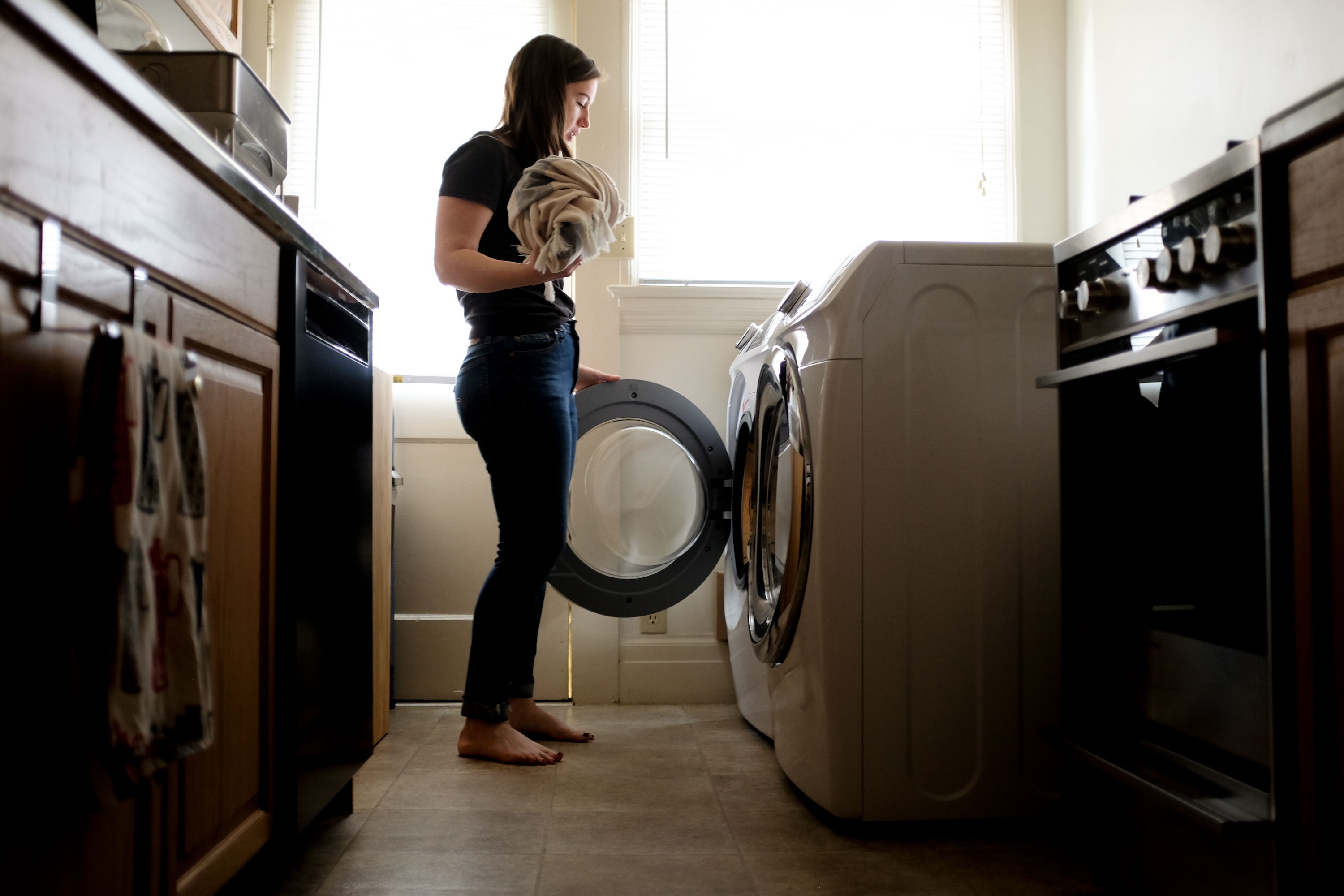 Alyssa puts a towel in the washing machine