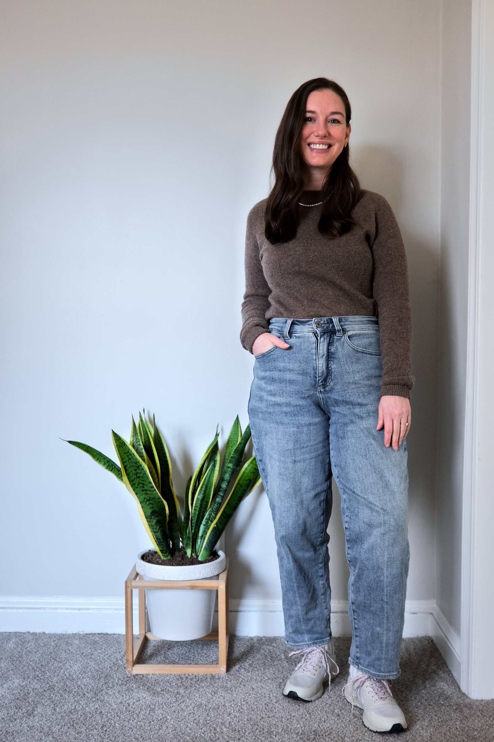 Alyssa wears a yak sweater from Quince in soft brown, and smiles at the camera