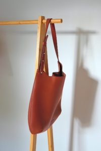 The Cactus Leather Hobo hangs on a clothing rack