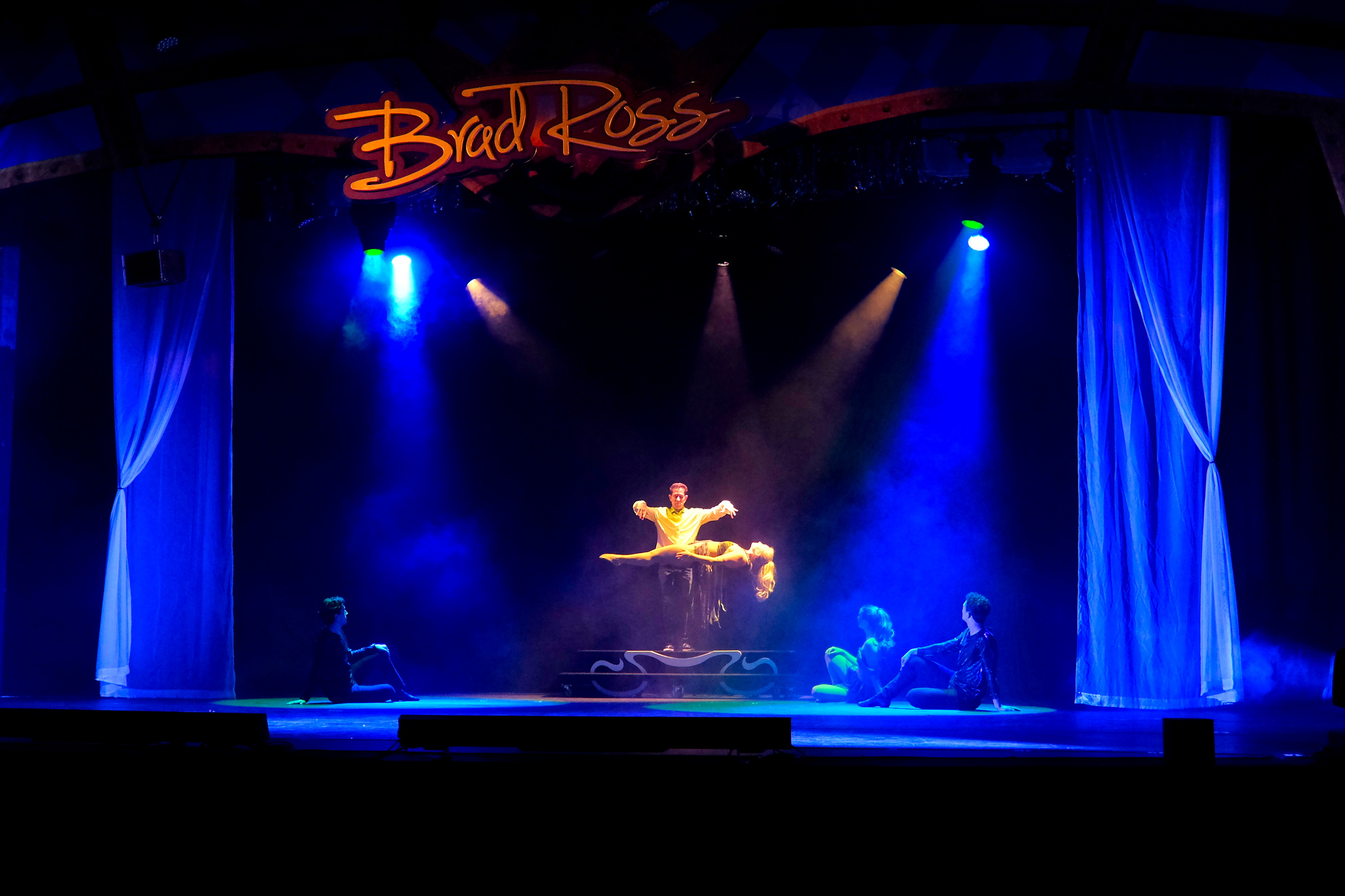 A magician levitates a woman during a performance