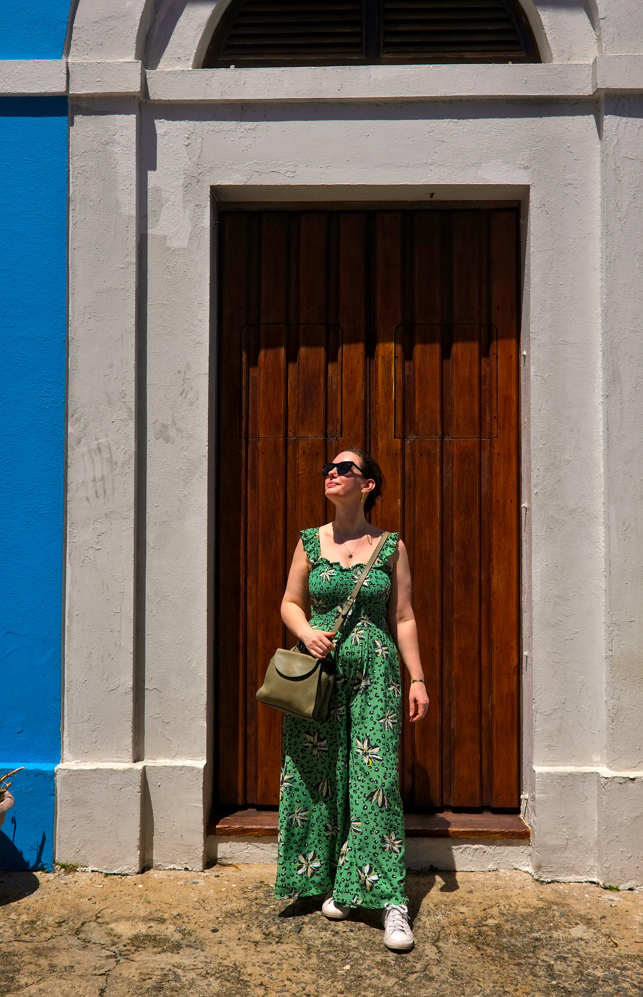 Alyssa in front of a blue building with a brown door in Old San Juan