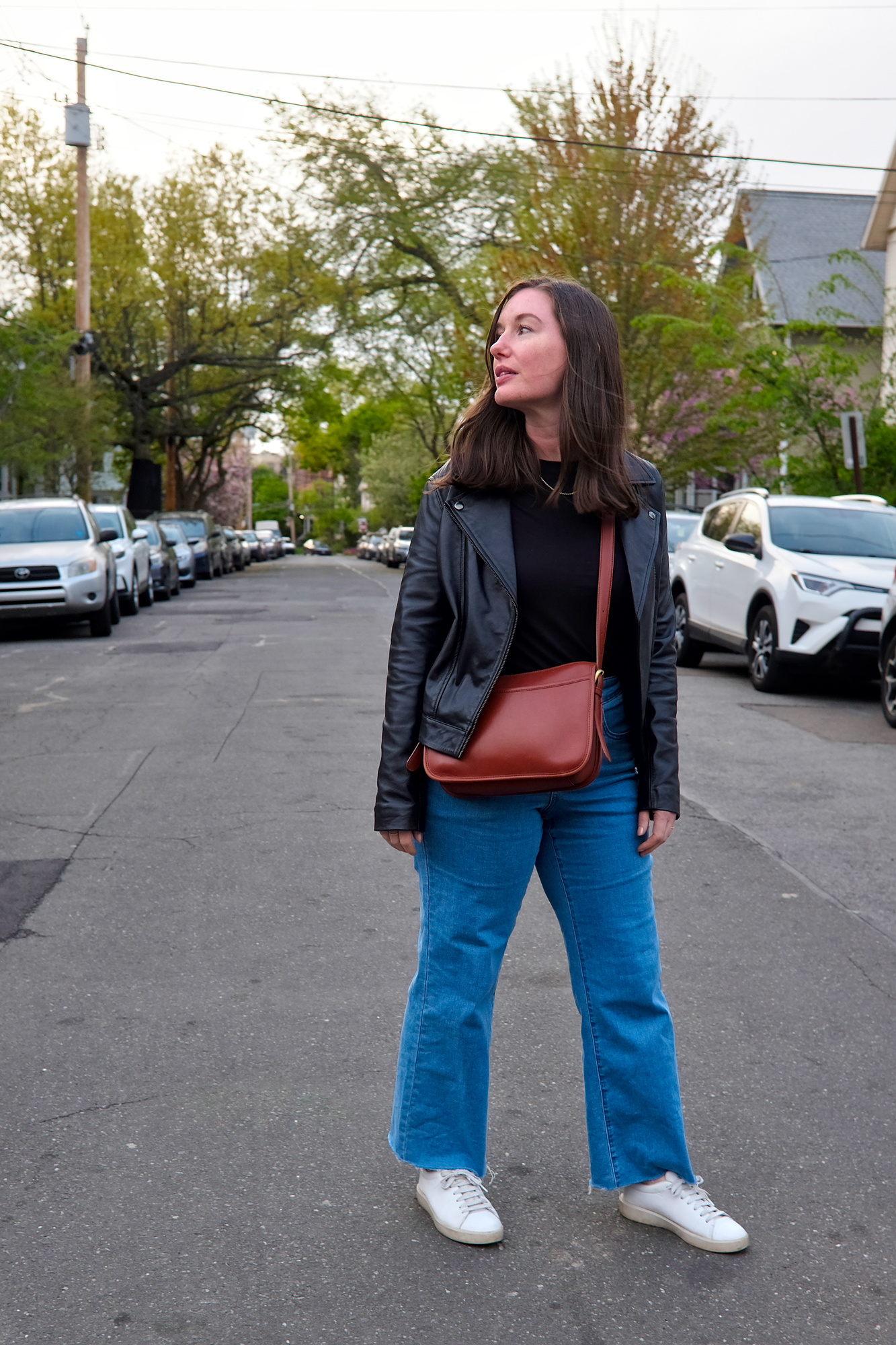 Alyssa wears a black tee, blue jeans, and white sneakers