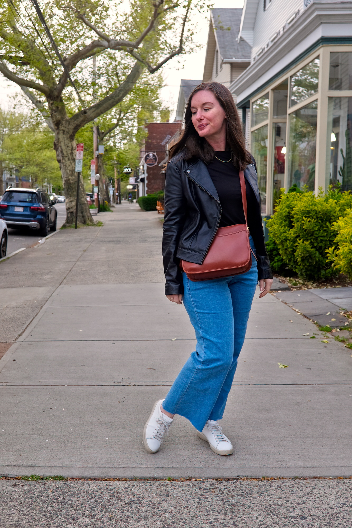 Alyssa wears a black tee, blue jeans, and brown purse in New Haven