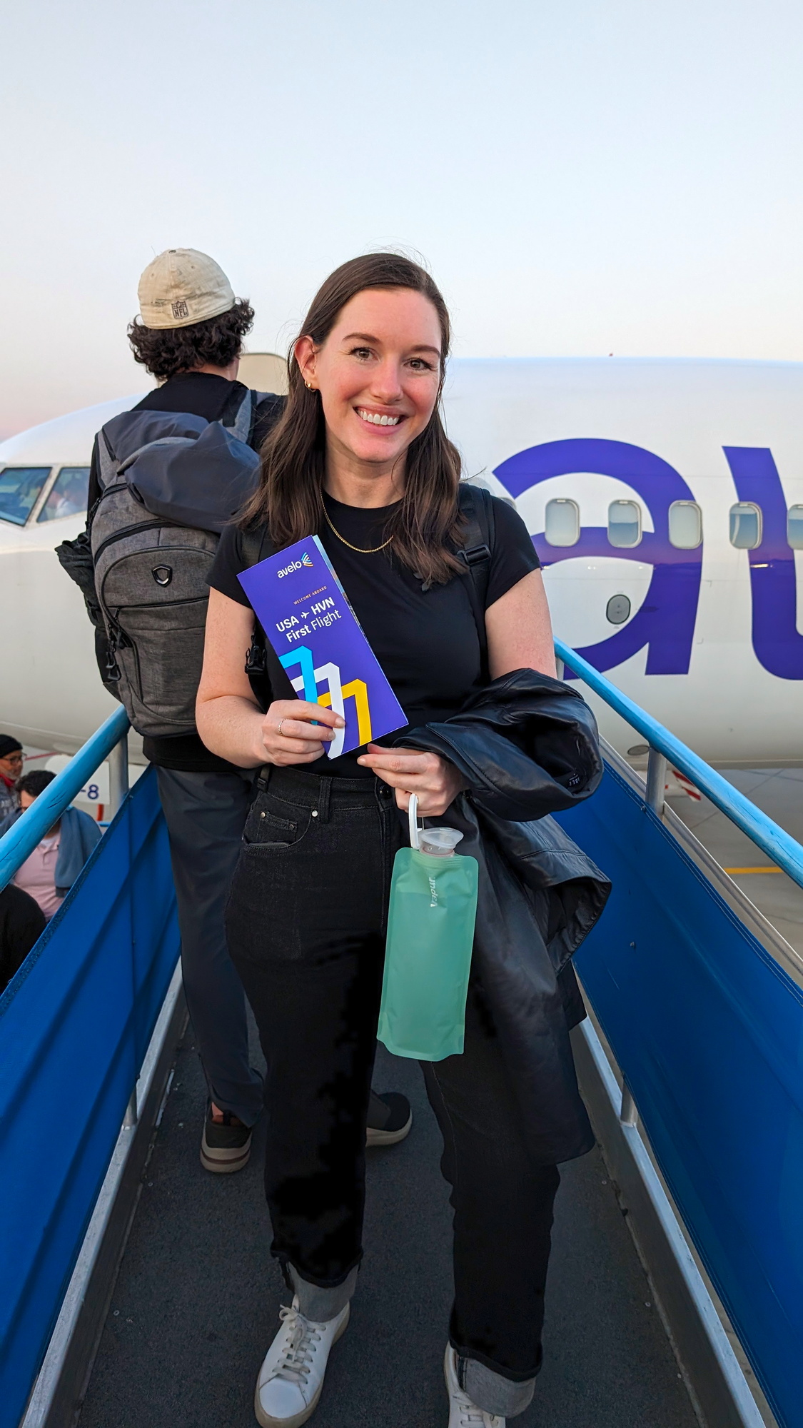 Alyssa gets ready to board the plane in a black tee and jeans