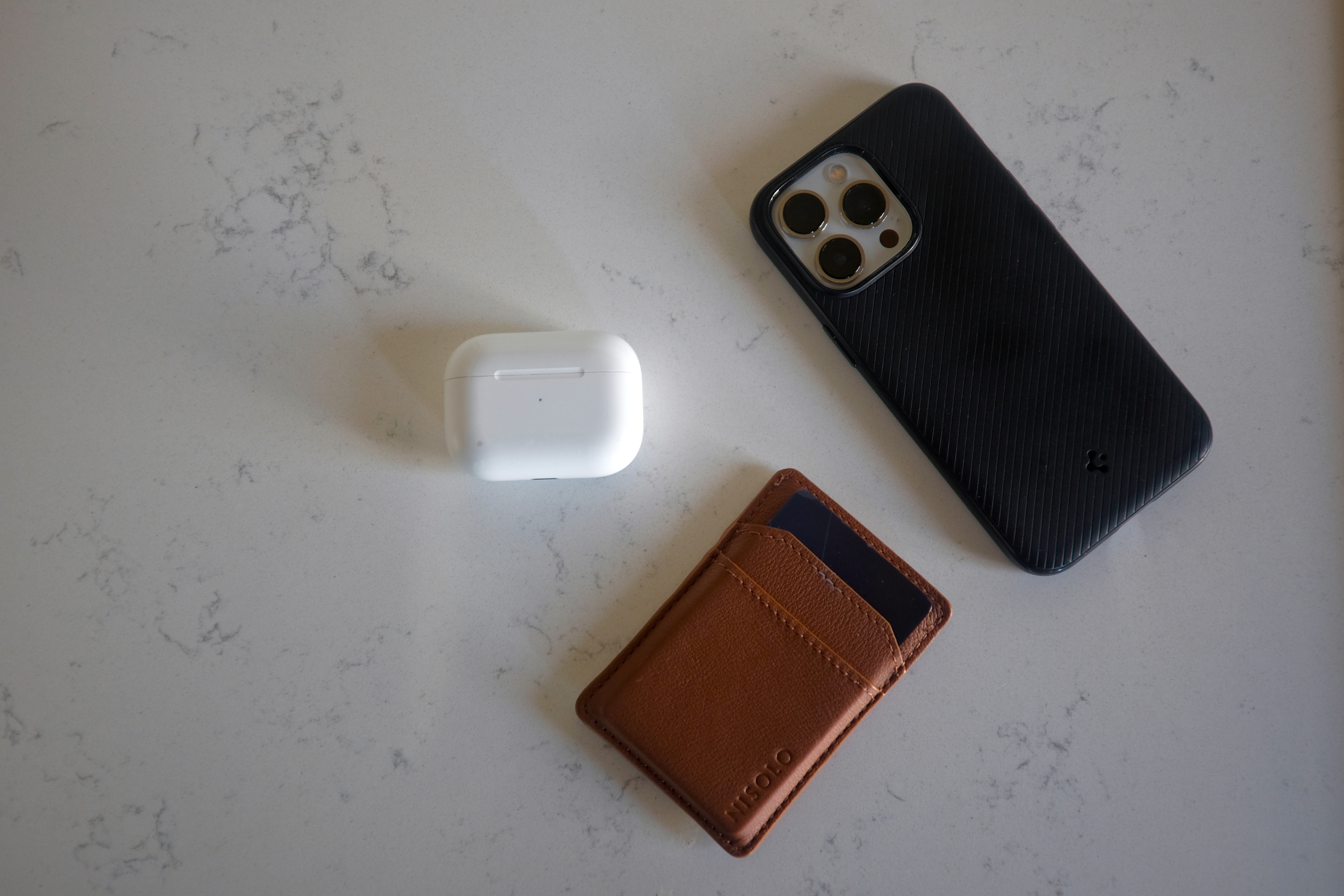 A phone, wallet, and Airpods