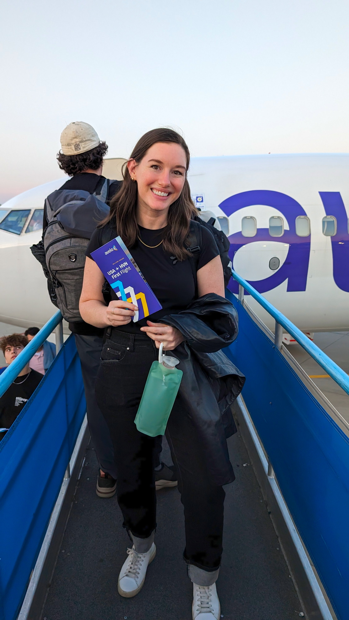 Alyssa in front of an Avelo plane