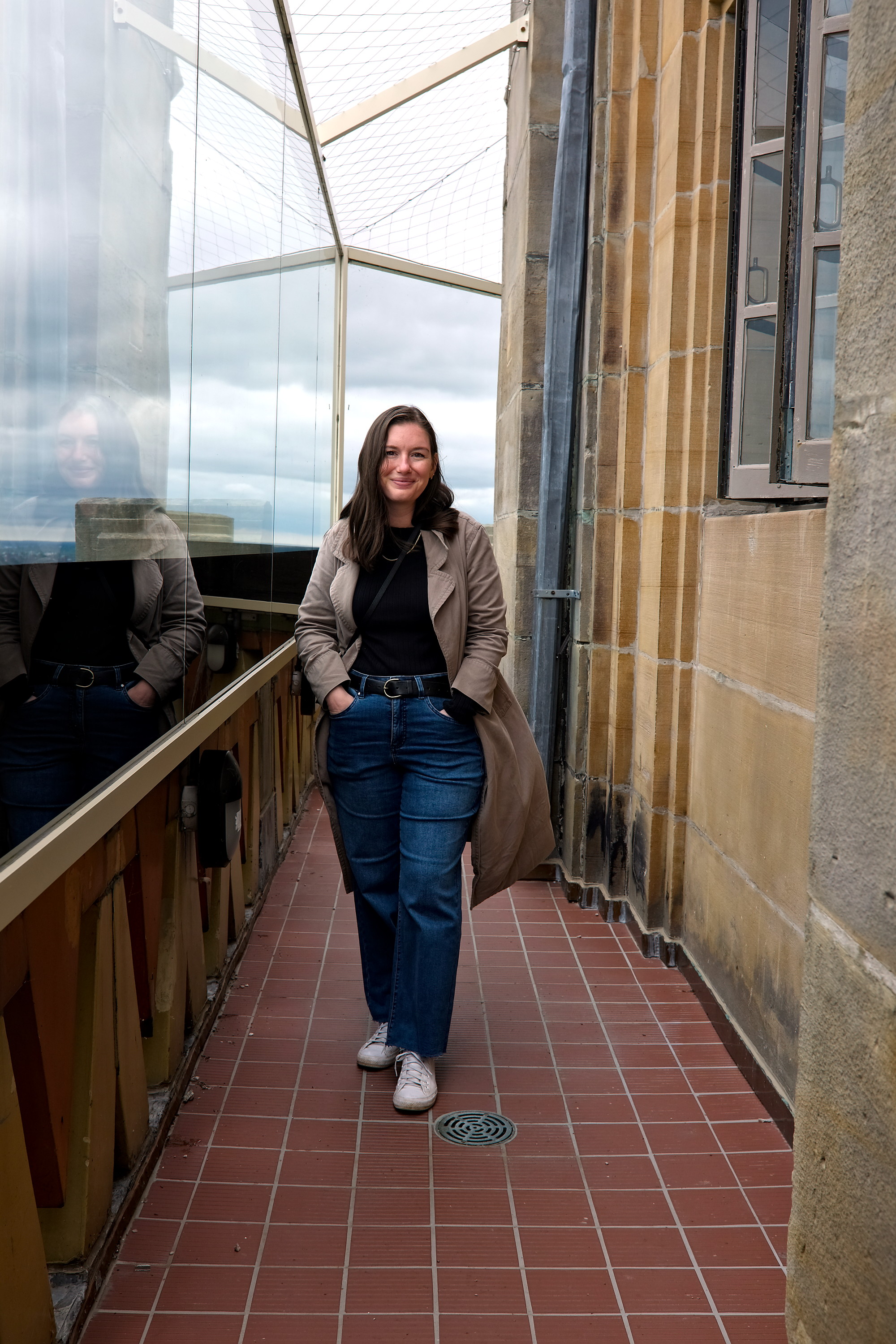 Alyssa walks on the Buffalo City Hall Observation Deck in a black tee and jeans