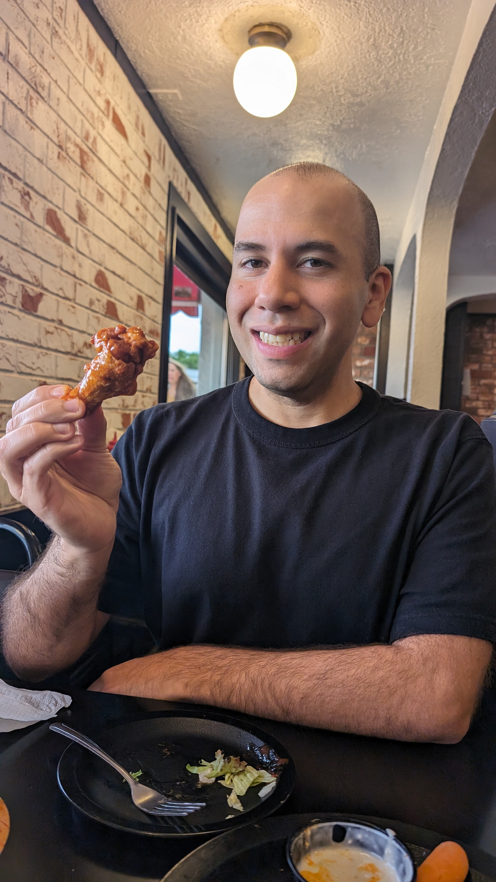 Michael holding up a chicken wing at Duff's