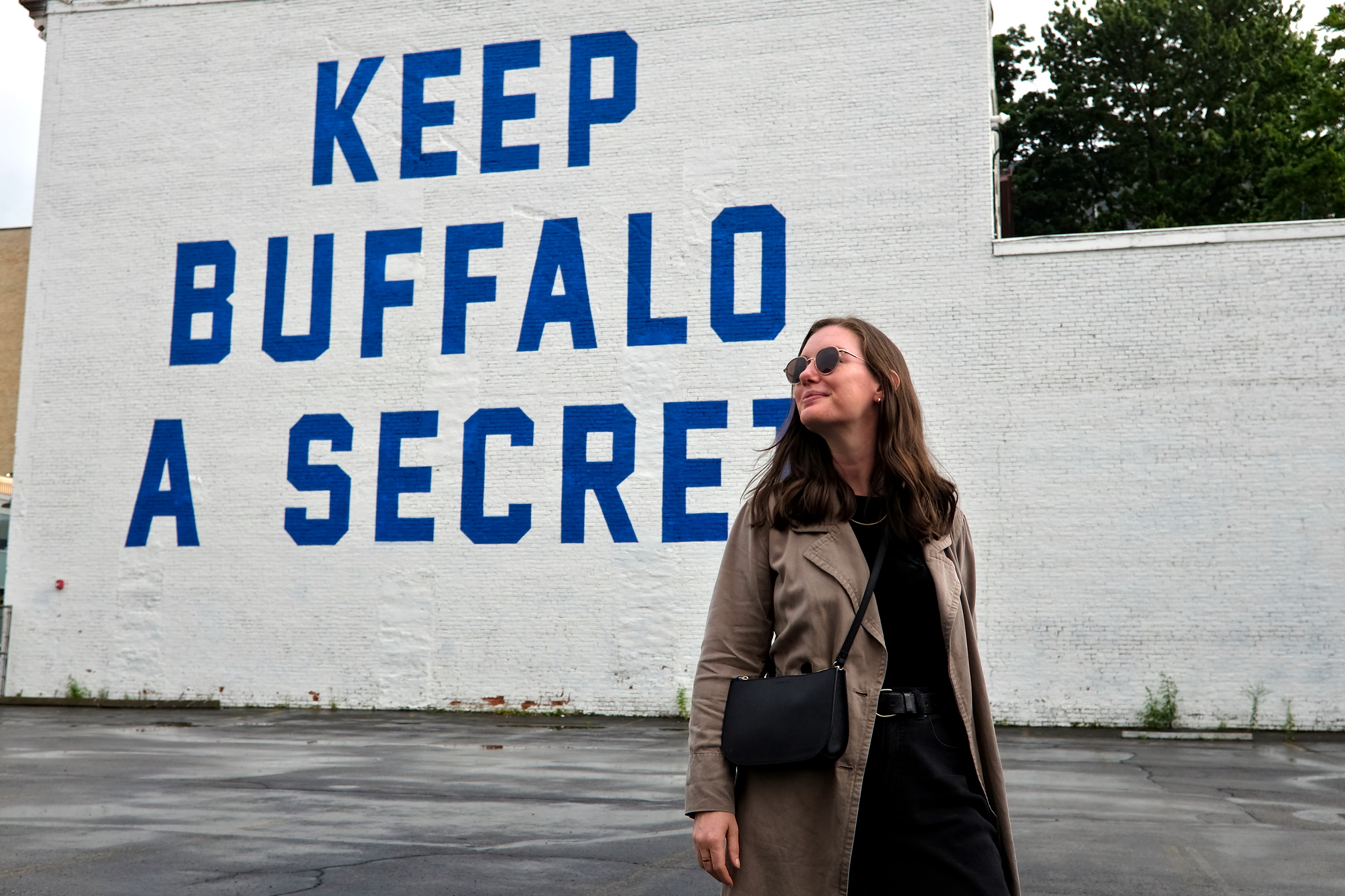 Alyssa stands in front of the Keep Buffalo a Secret Mural