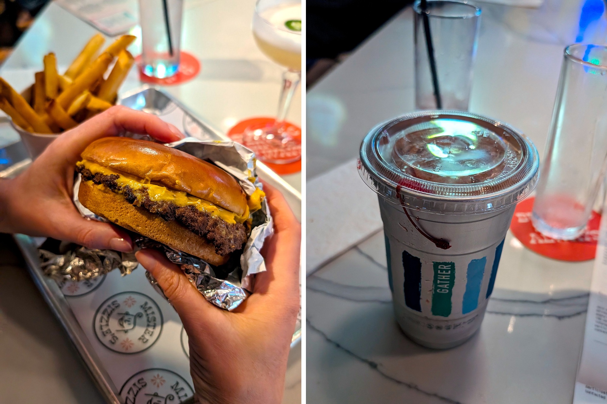 A pair of hands holding a burger and a shake in an aluminum cup