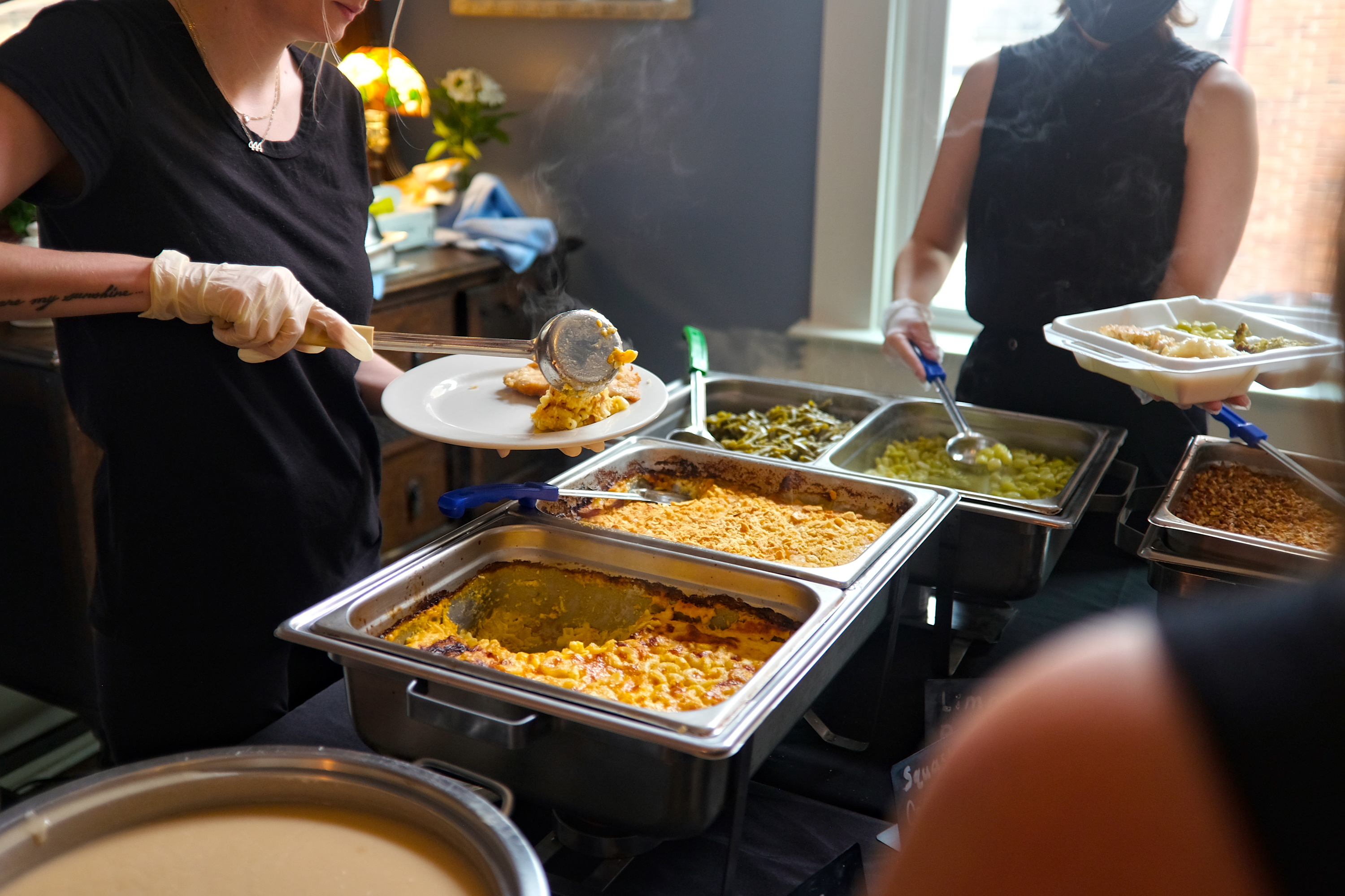 Servers plate from a buffet of Southern cuisine