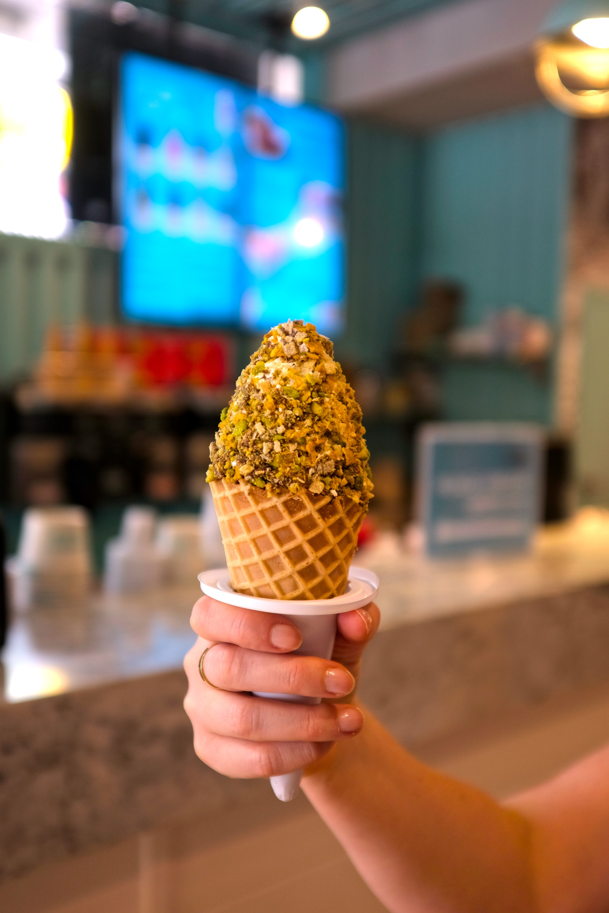 A hand holds an ice cream cone from Sweet Jesus 