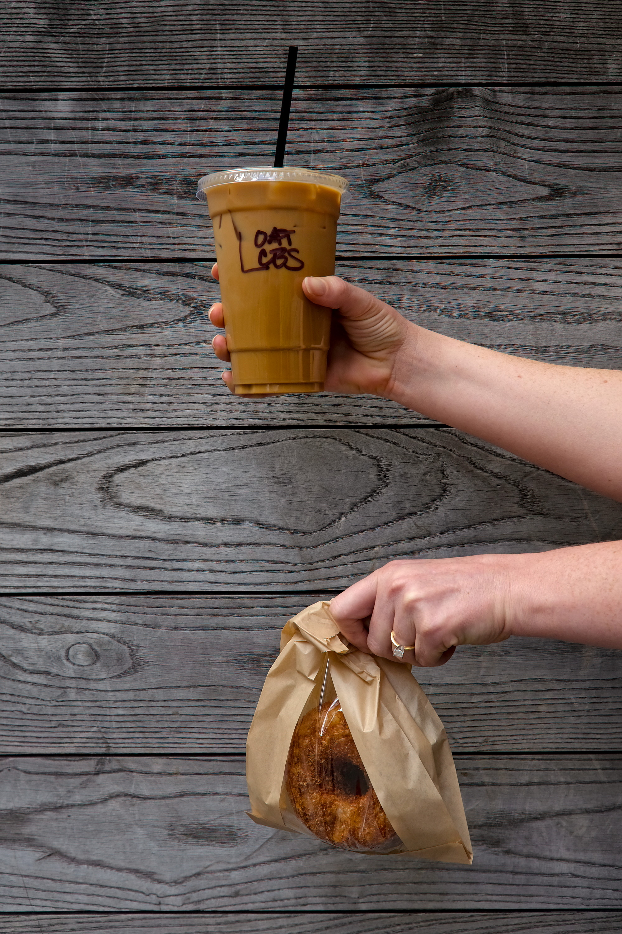 Alyssa holds an iced latte and a cronut