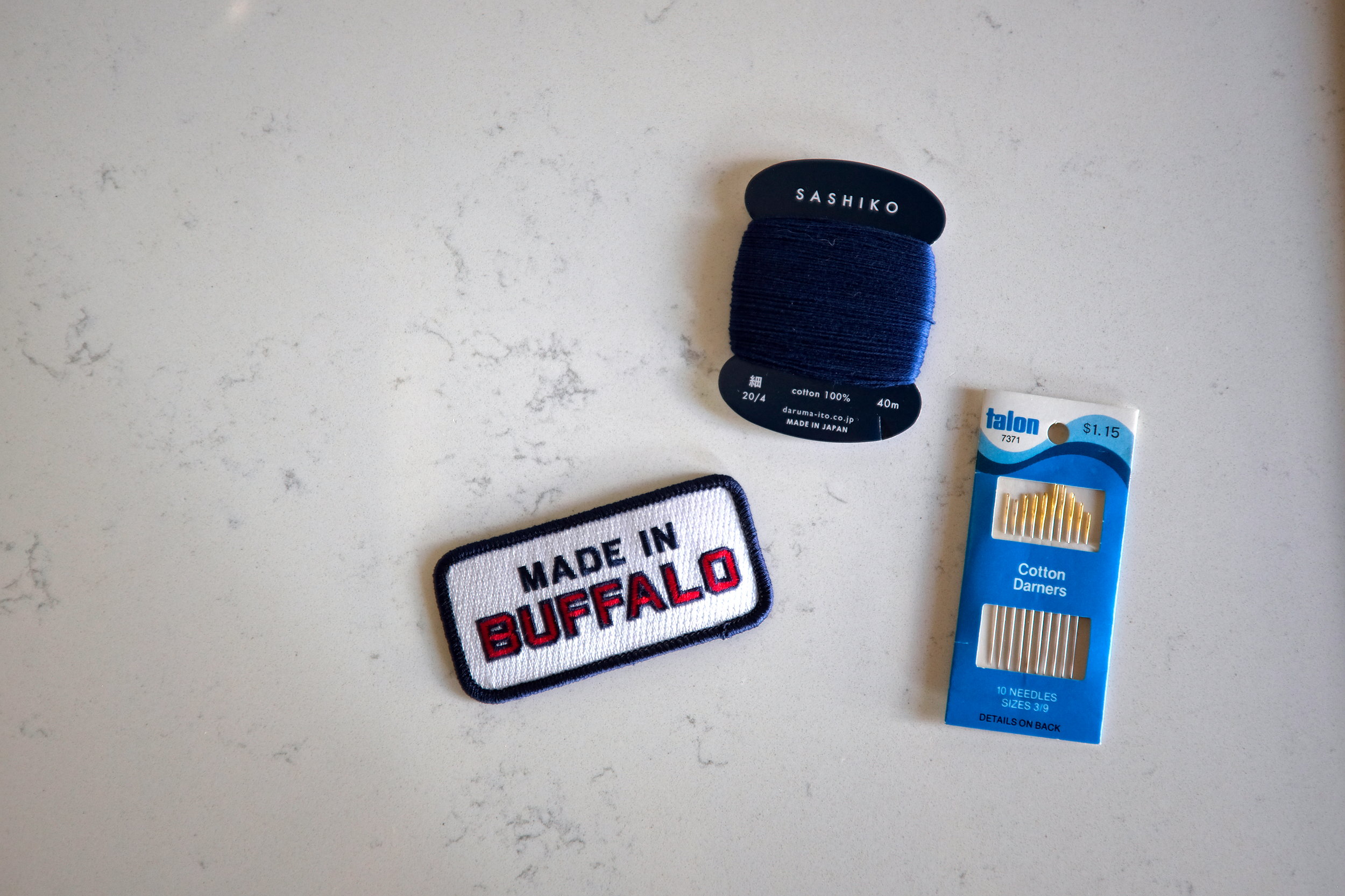 A patch, thread, and darning needles