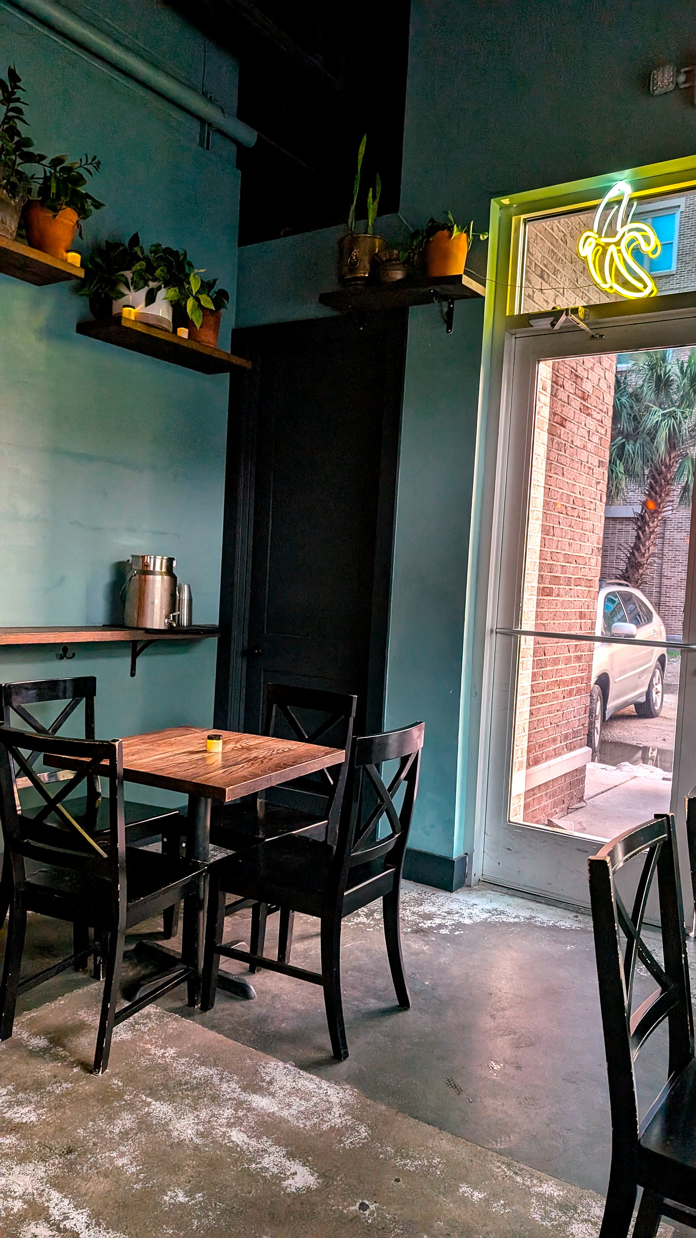 Seating at Dalila's in Charleston, with a neon banana sign