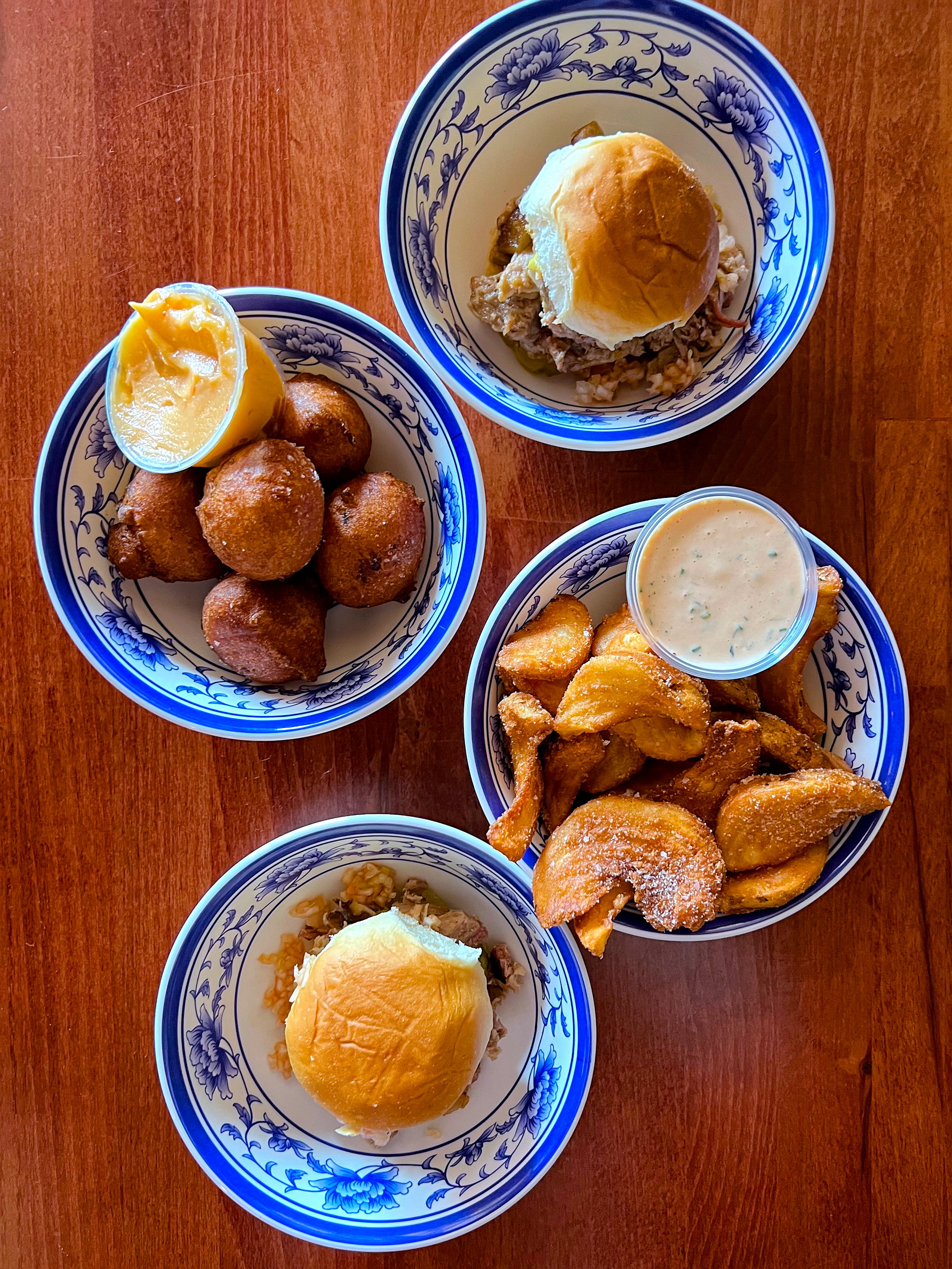 A table of sliders, hushpuppies, and potato wedges at King BBQ