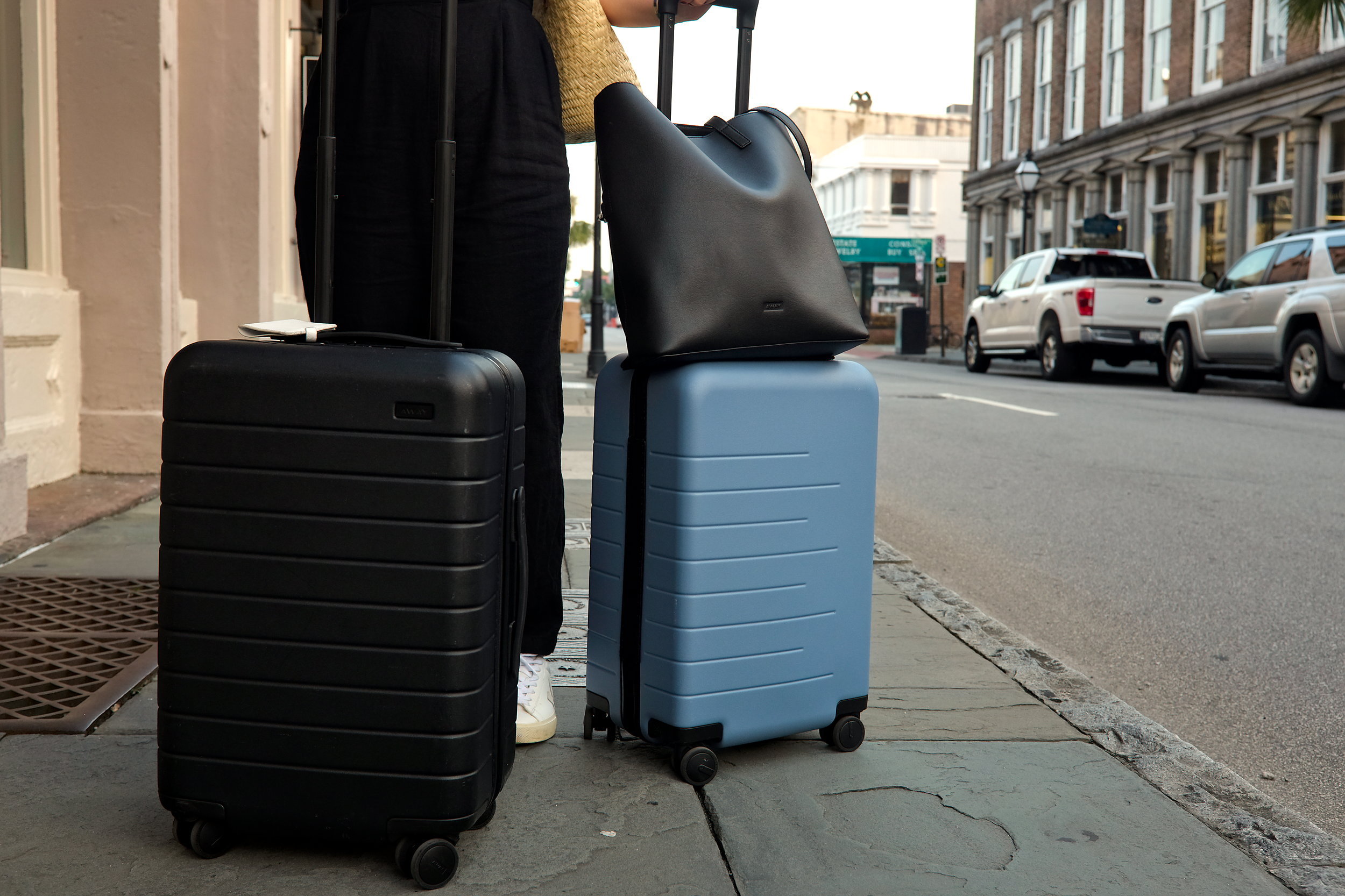 Alyssa pulls two suitcases down a street in Charleston