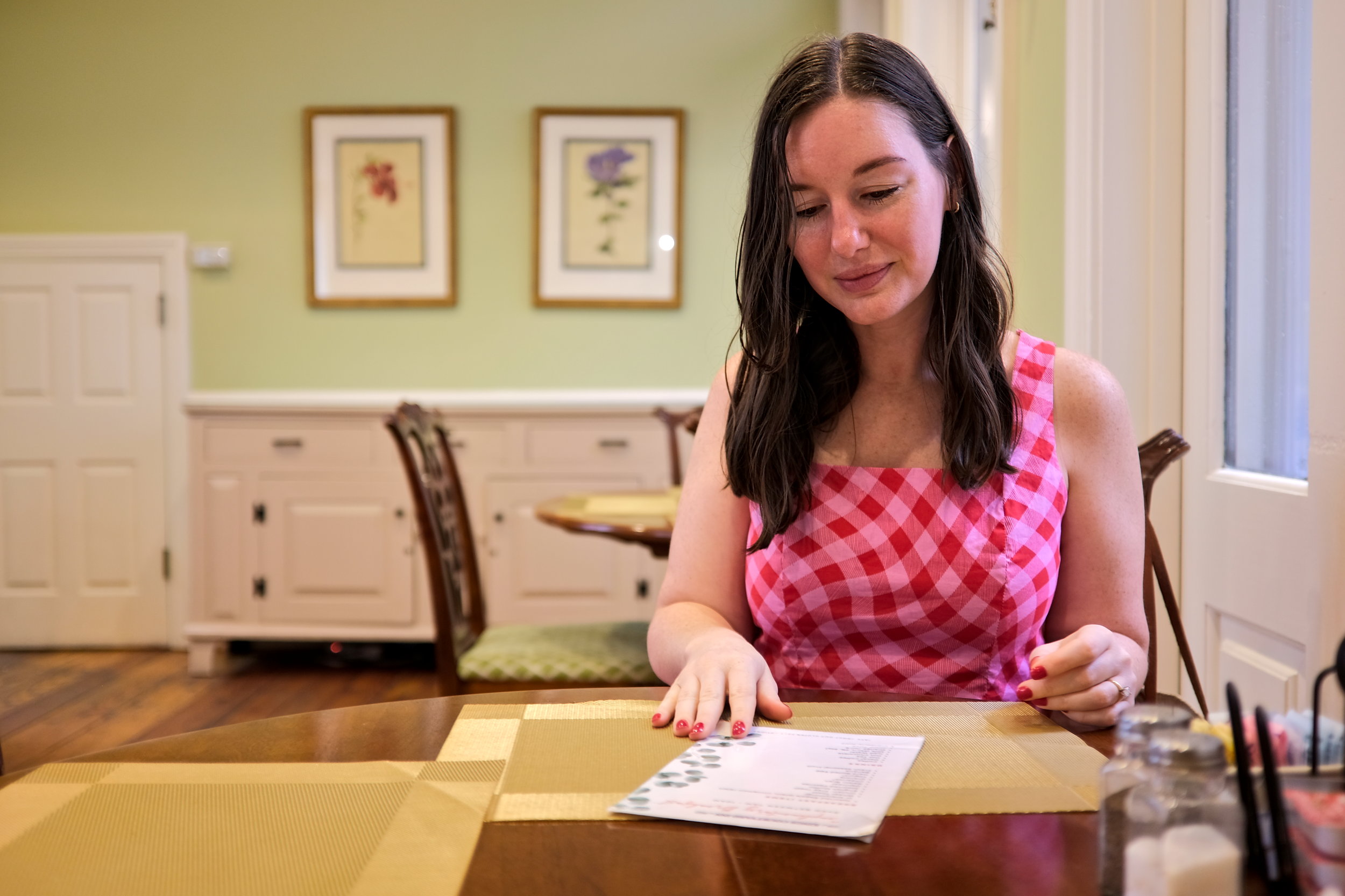 Alyssa wears a pink tank top and looks over a menu