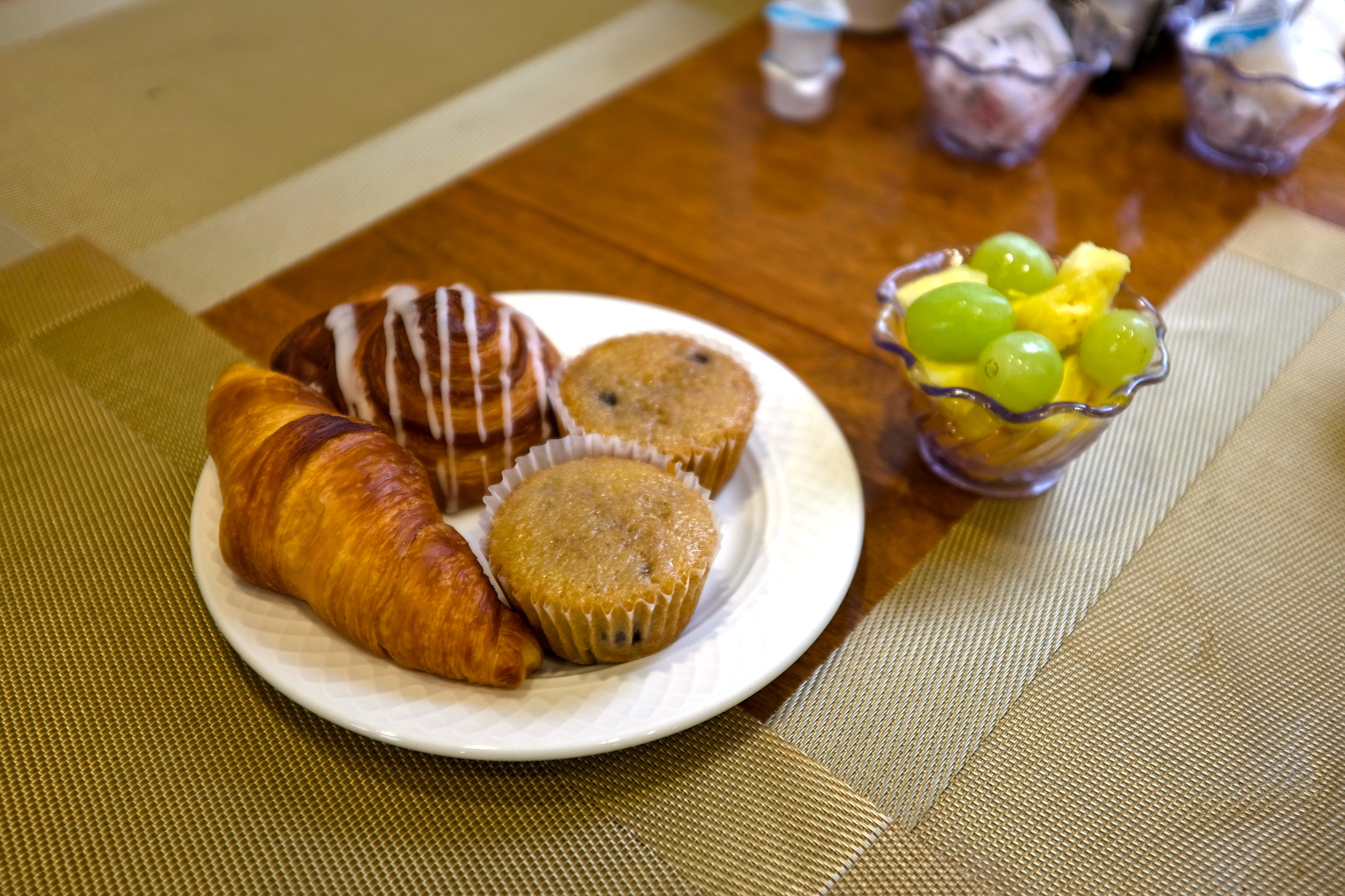 A plate of pastries and a cup of fruit