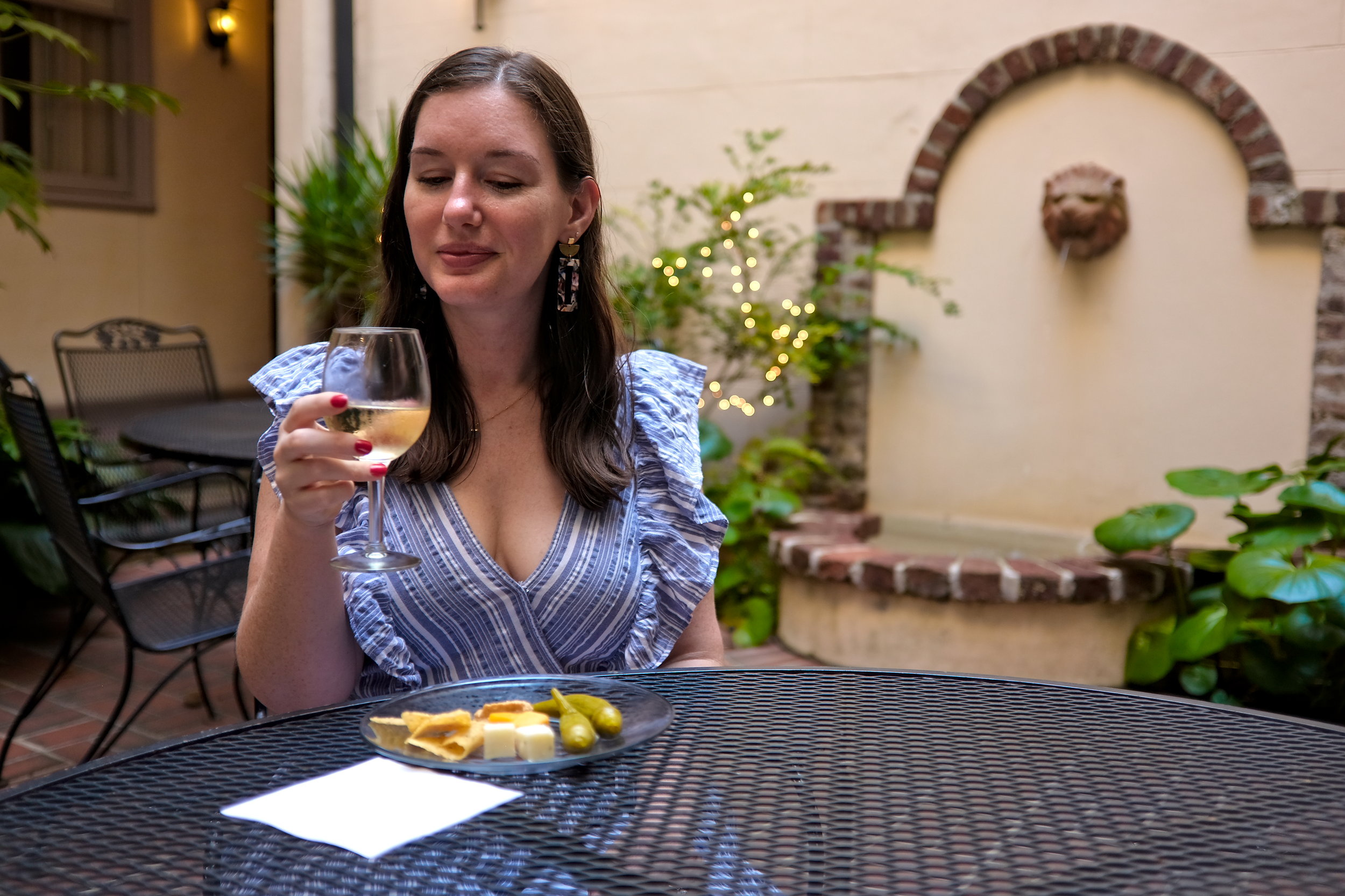 Alyssa with a glass of wine and plate of cheese at Kings Courtyard Inn