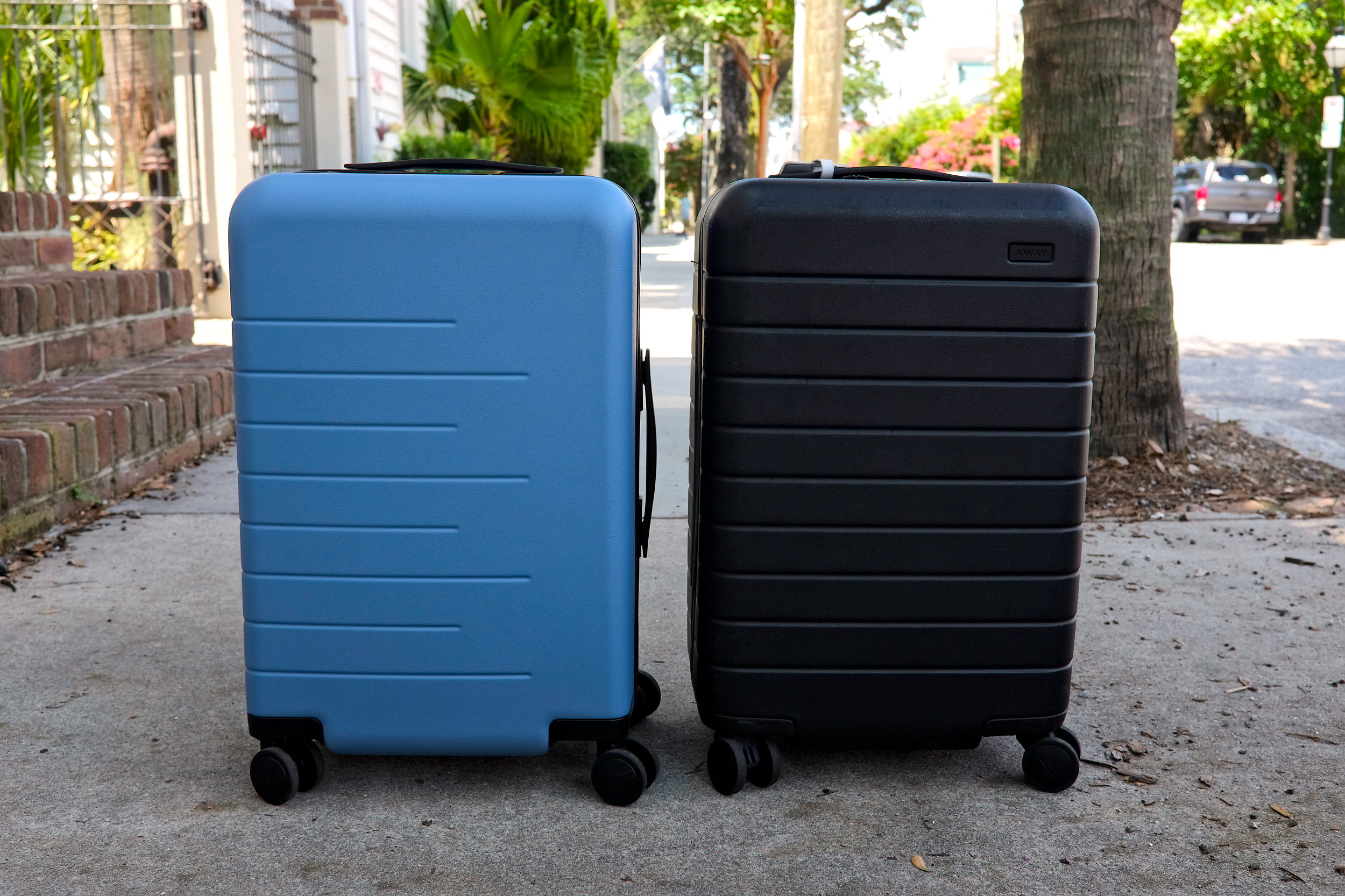 The Quince and Away suitcases are side-by-side on a sidewalk in Charleston