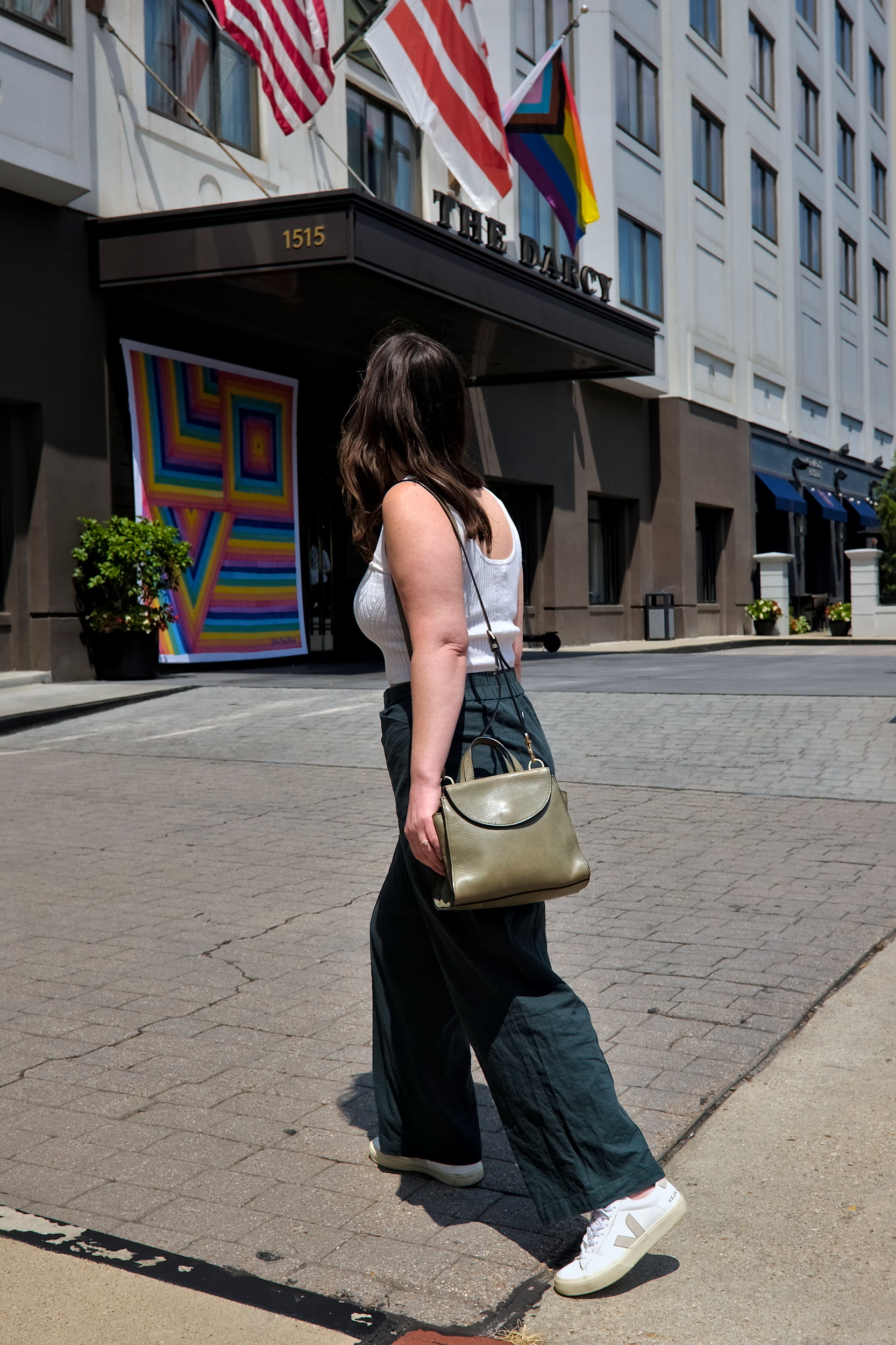 Alyssa walks toward The Darcy Hotel