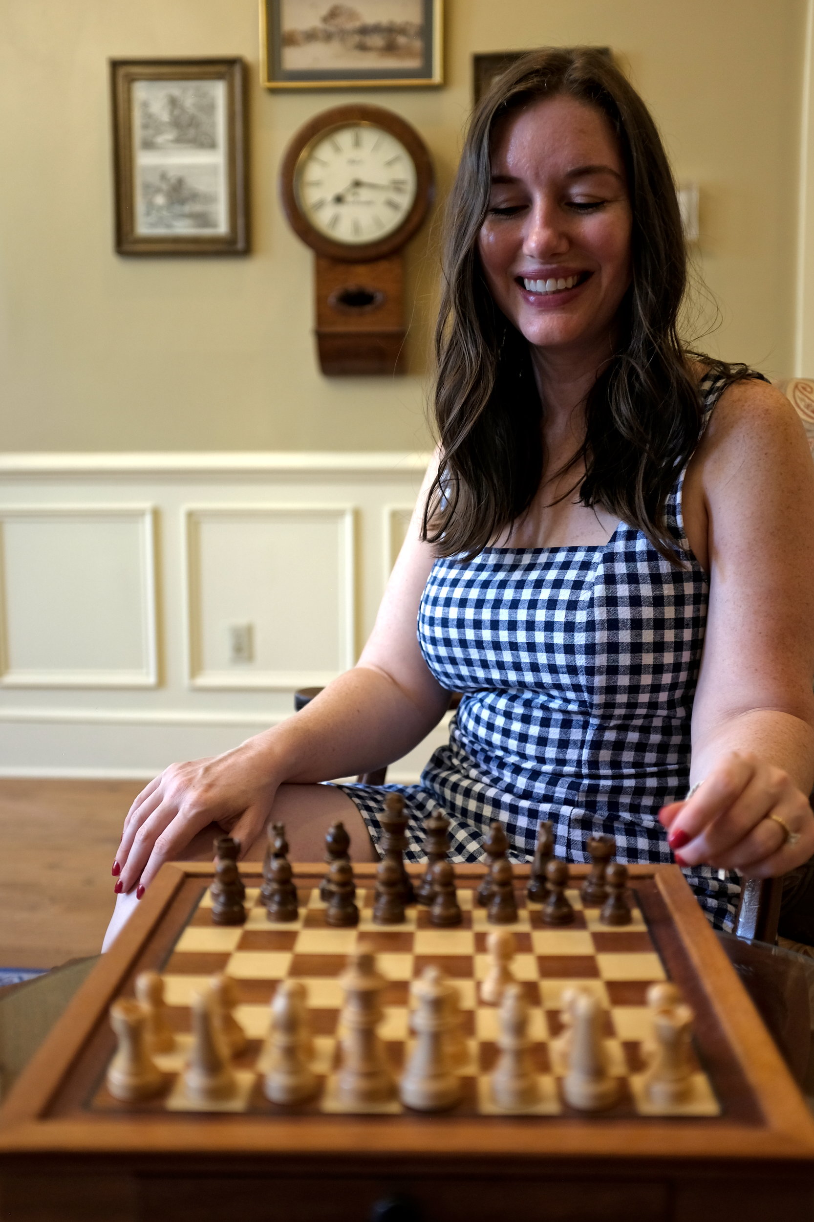 Alyssa wears a gingham dress from the Charleston packing list and plays chess at the Kings Courtyard Inn