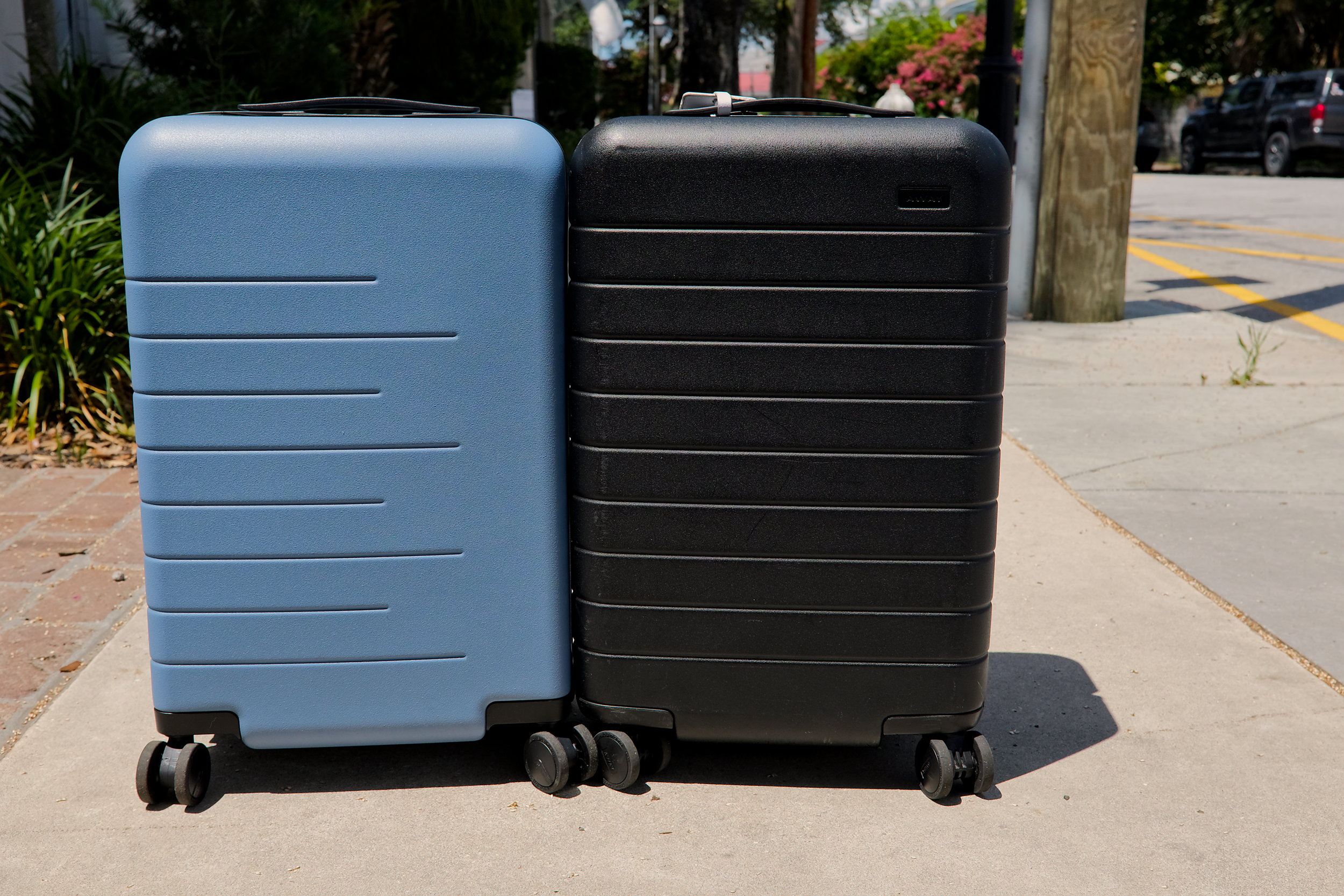 The Quince and Away carry-on suitcases are side by side on a Charleston sidewalk