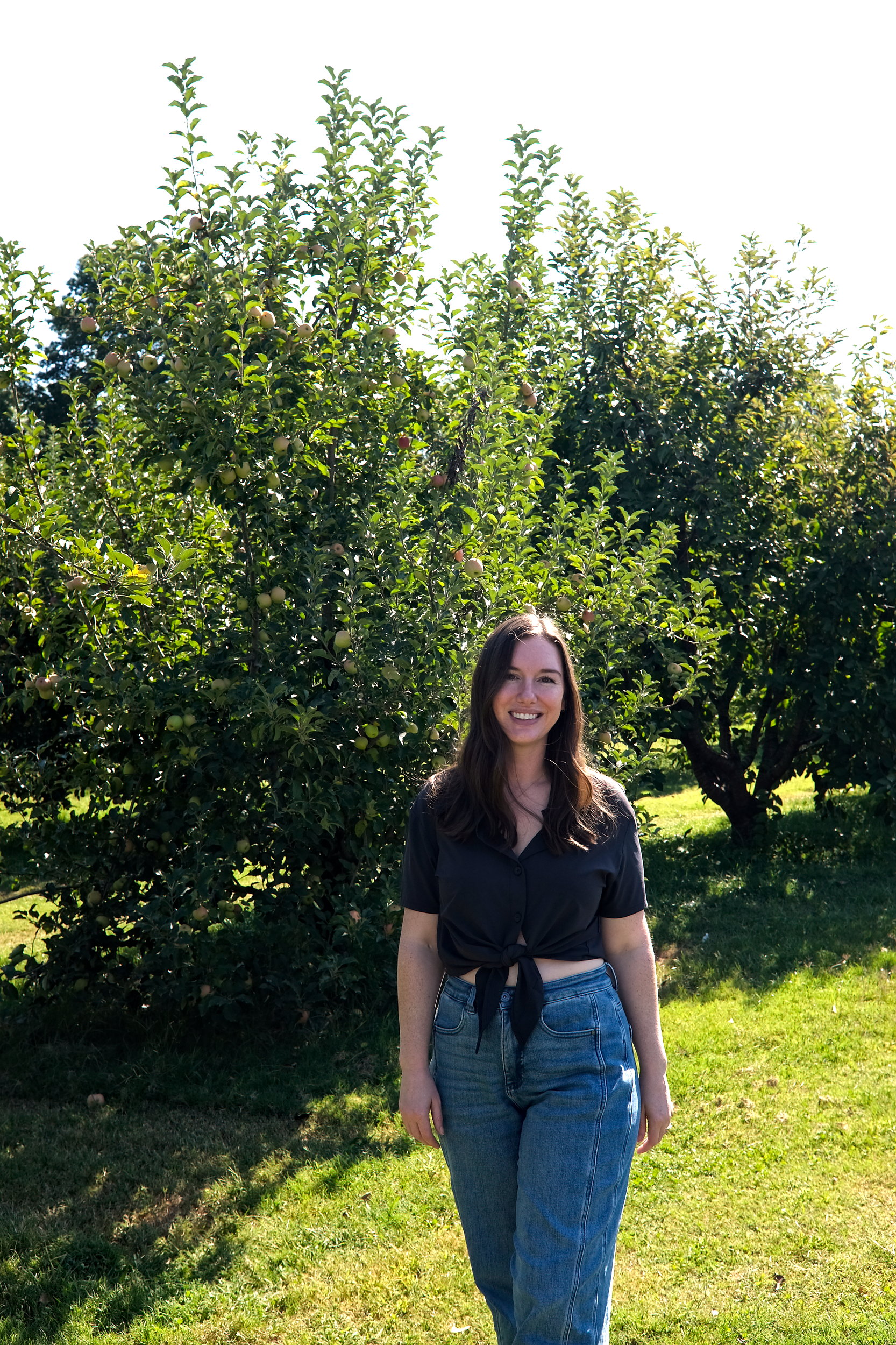 Alyssa in front of an apple tree at Carver's Orchard & Applehouse Restaurant