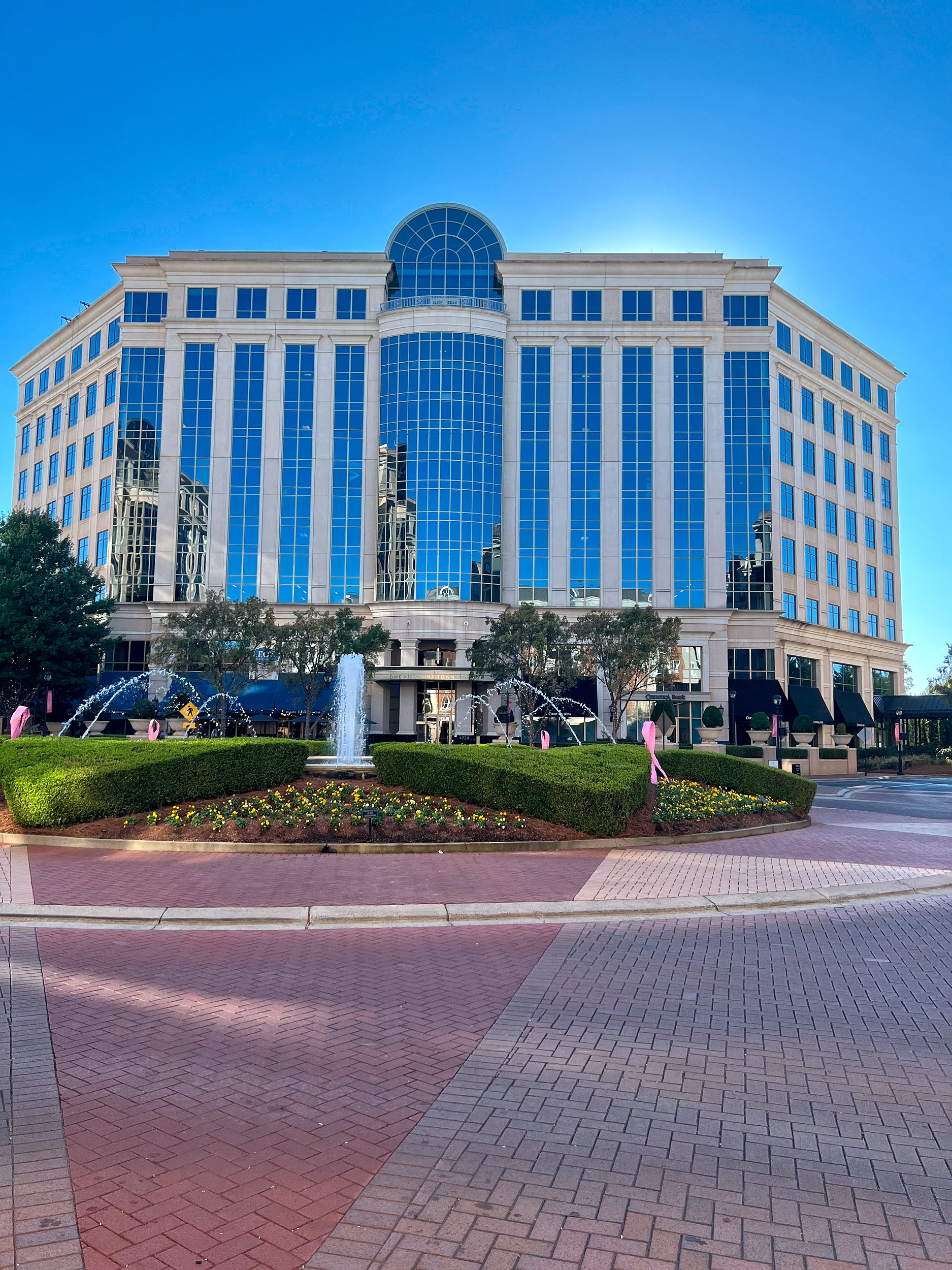 A fountain with a large building in the background at Piedmont Town Center