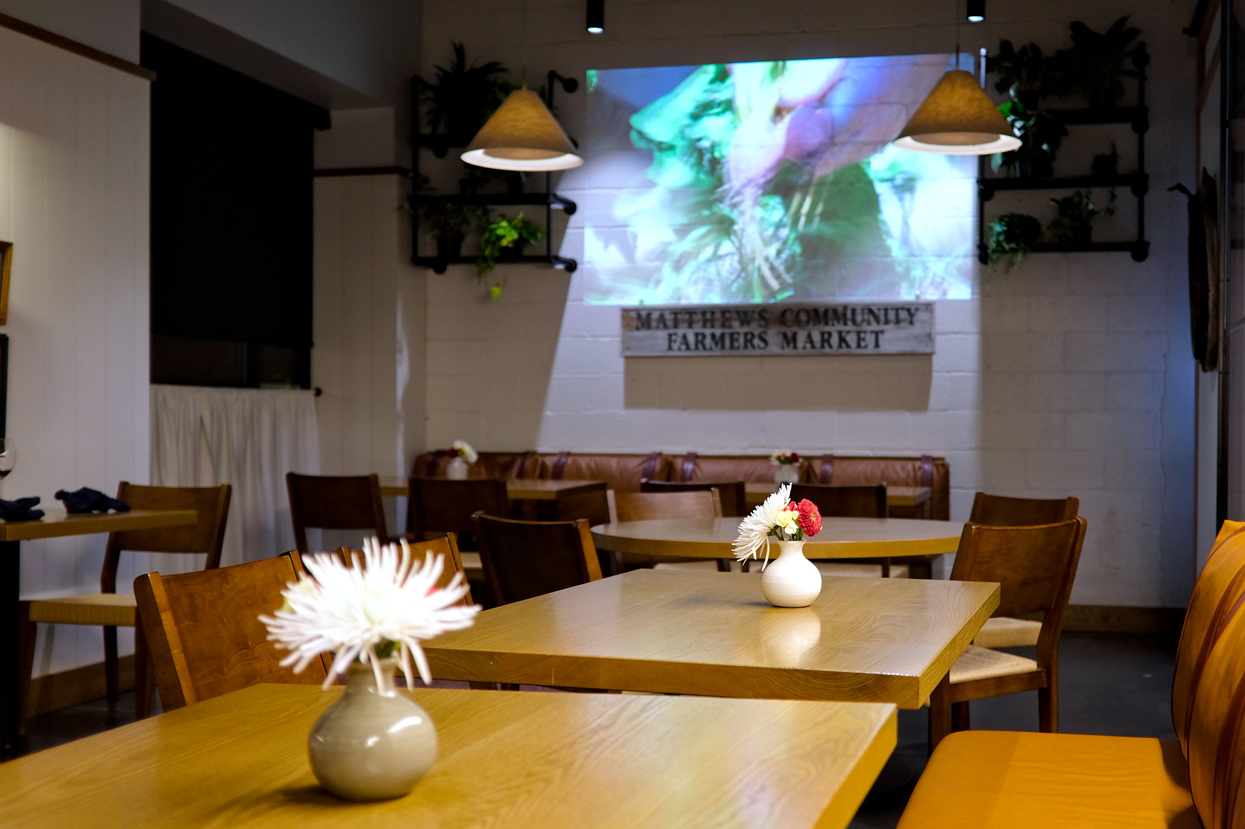 View of the dining room at Restaurant Constance and a projector playing video from local farms