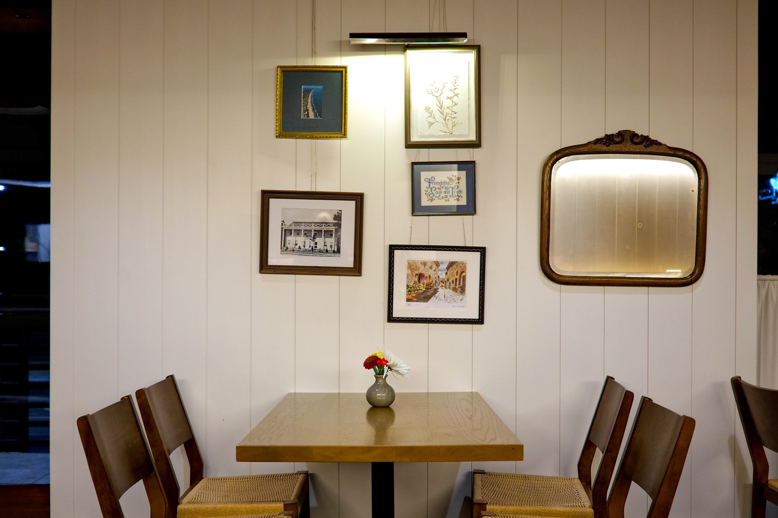 A table, chairs, and art on the wall at Restaurant Constance