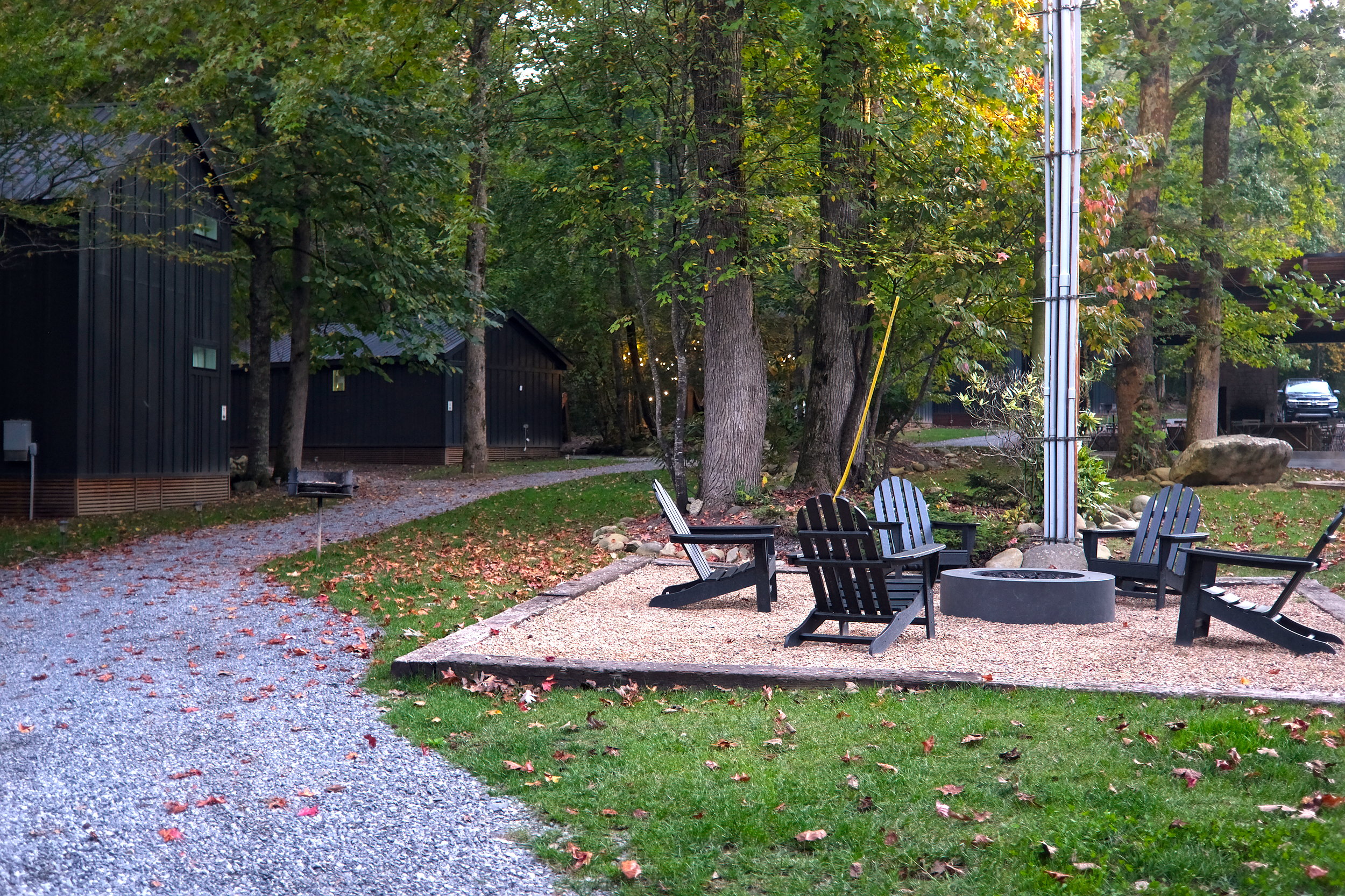 A group of chairs surround a fire pit next to cabins