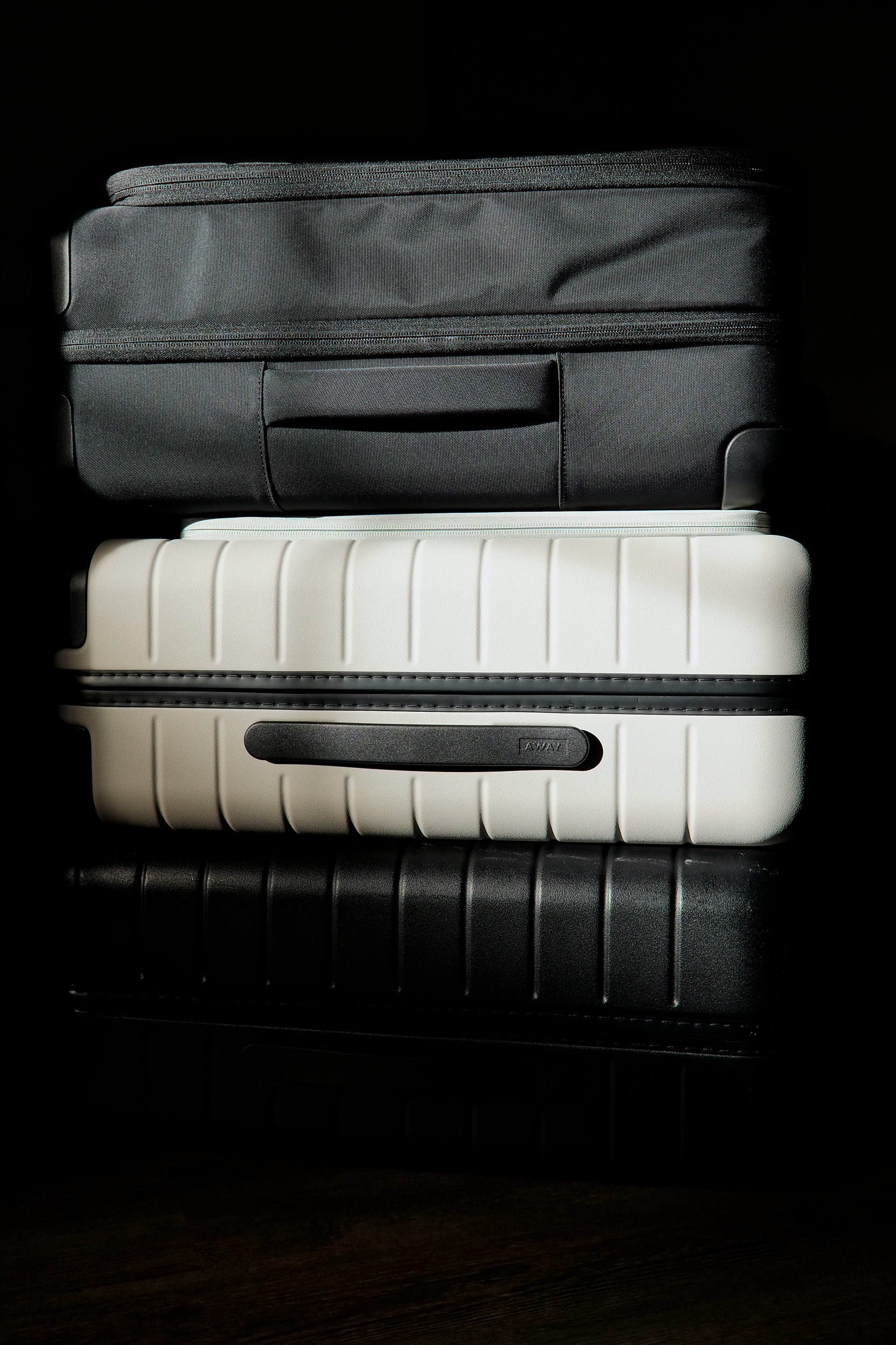 A stack of three Away Carry-On suitcases