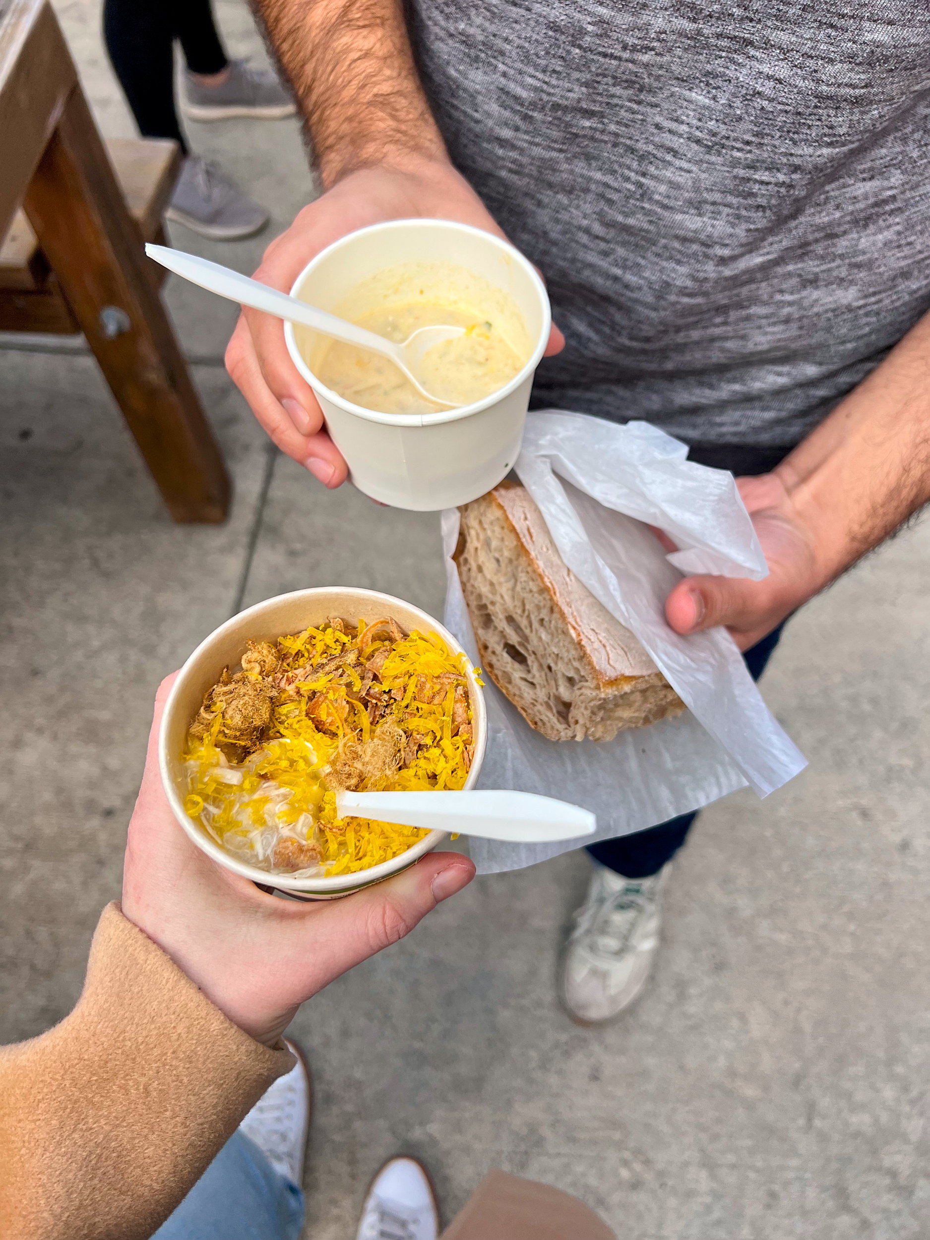 Alyssa and Michael hold out bowls of soup at Free Soup Day