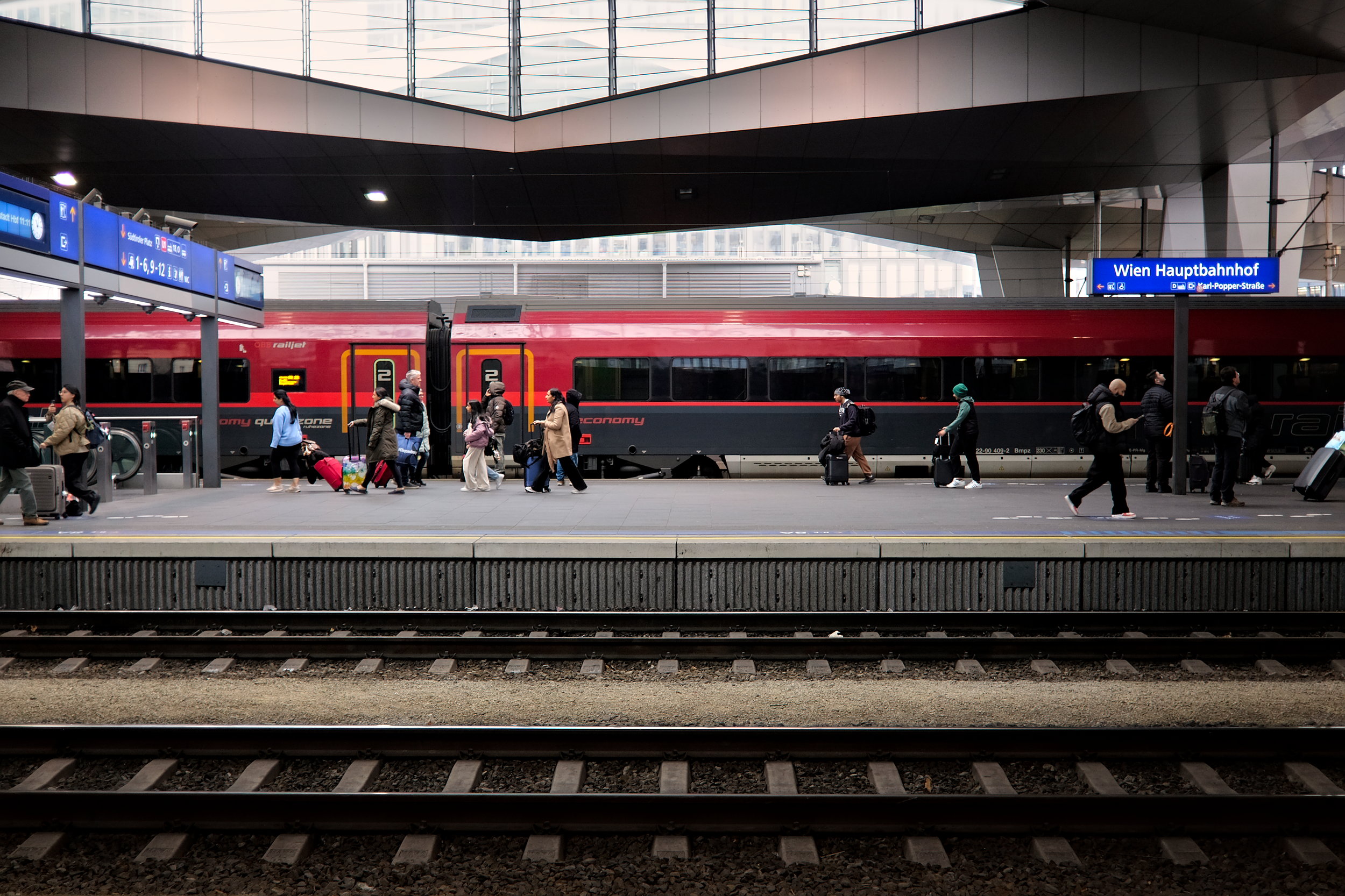 People walk next to the train at Wien Hauptbahnhof