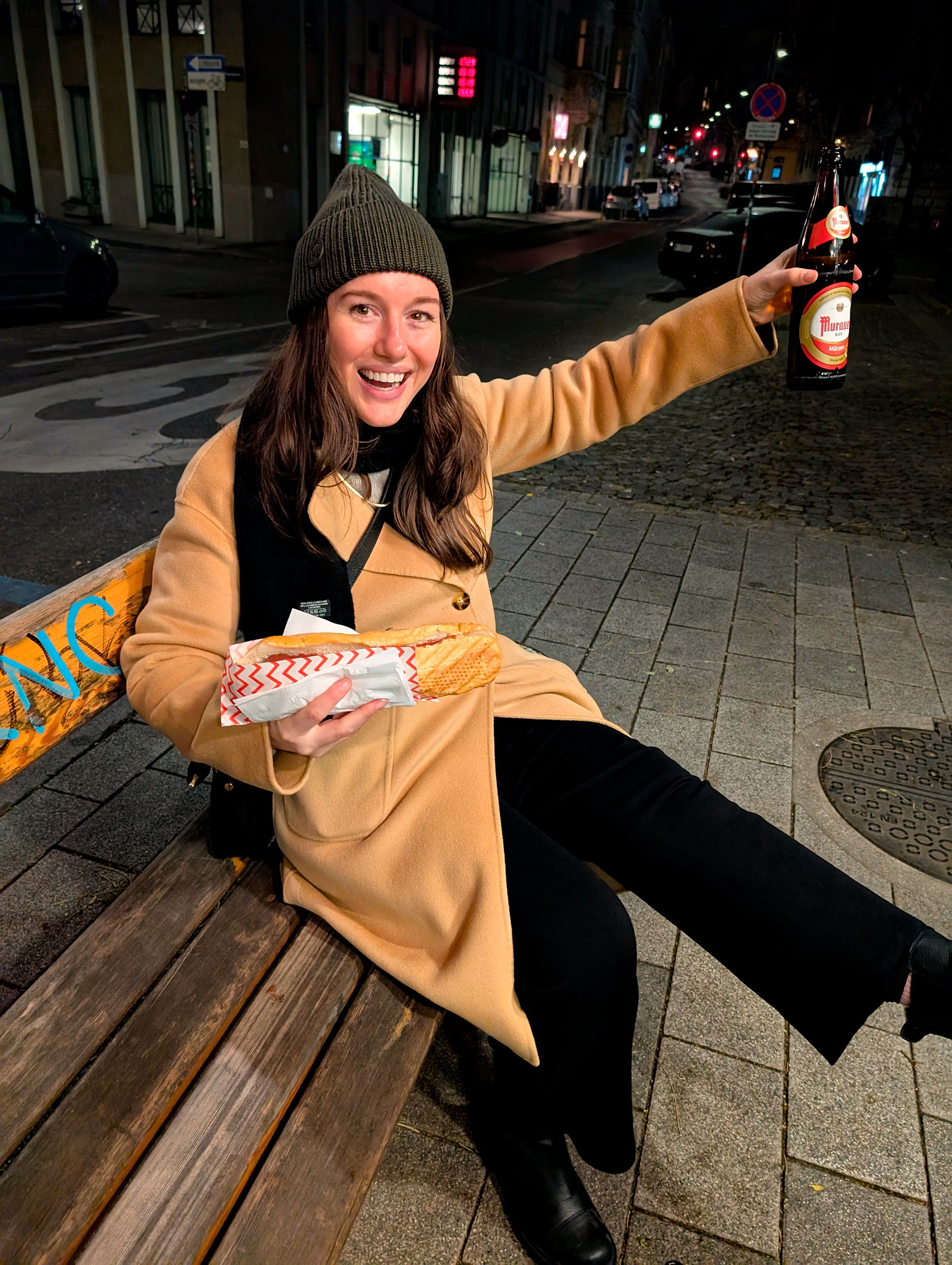 Alyssa holds a käsekrainer and a beer