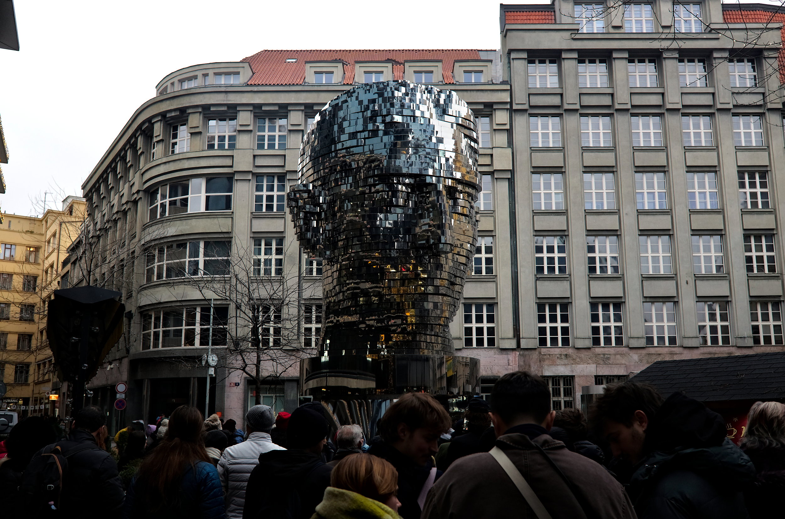 Visitors in front of the Kafka Head sculpture