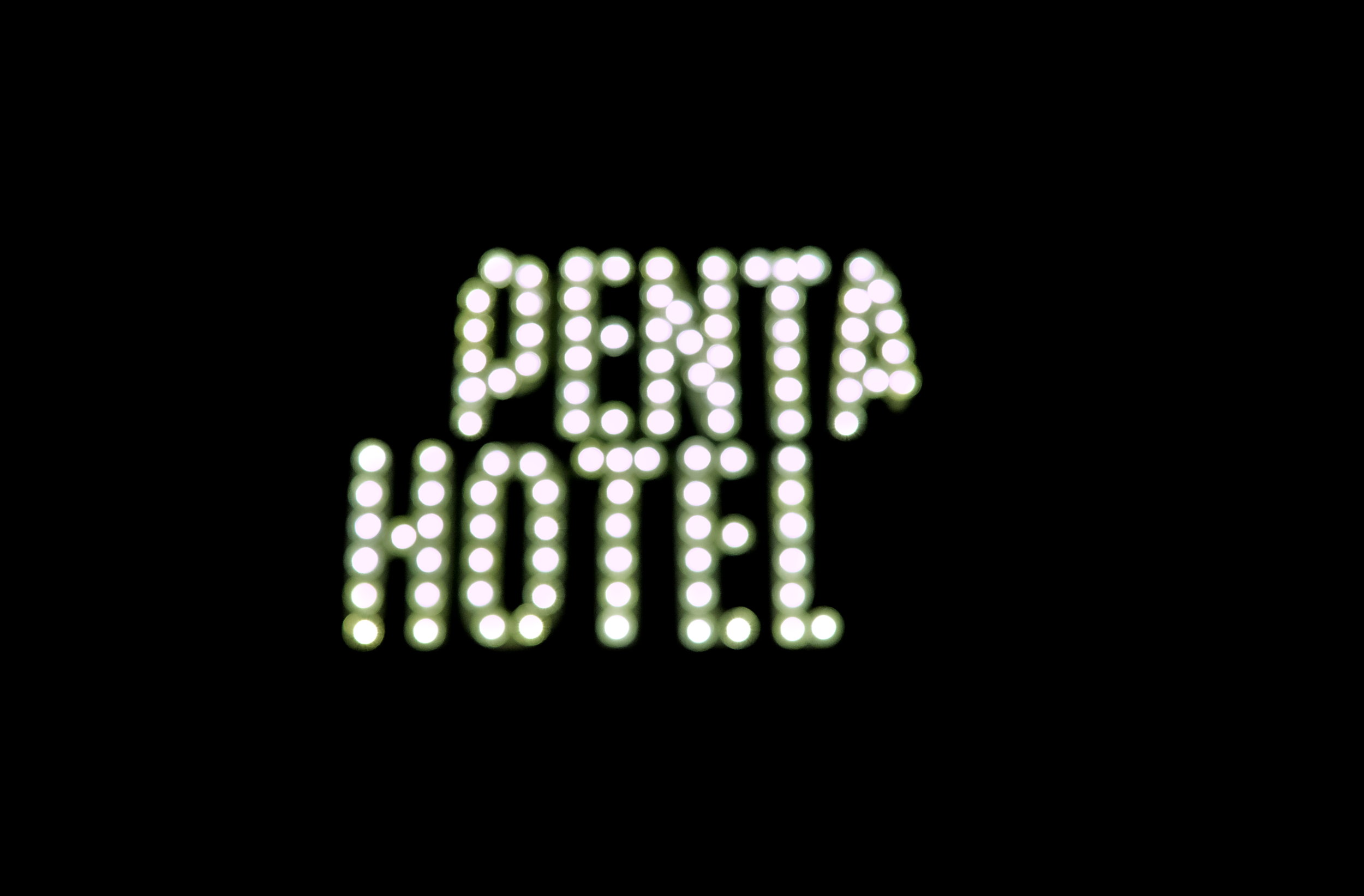 The logo for Penta Hotel in lights