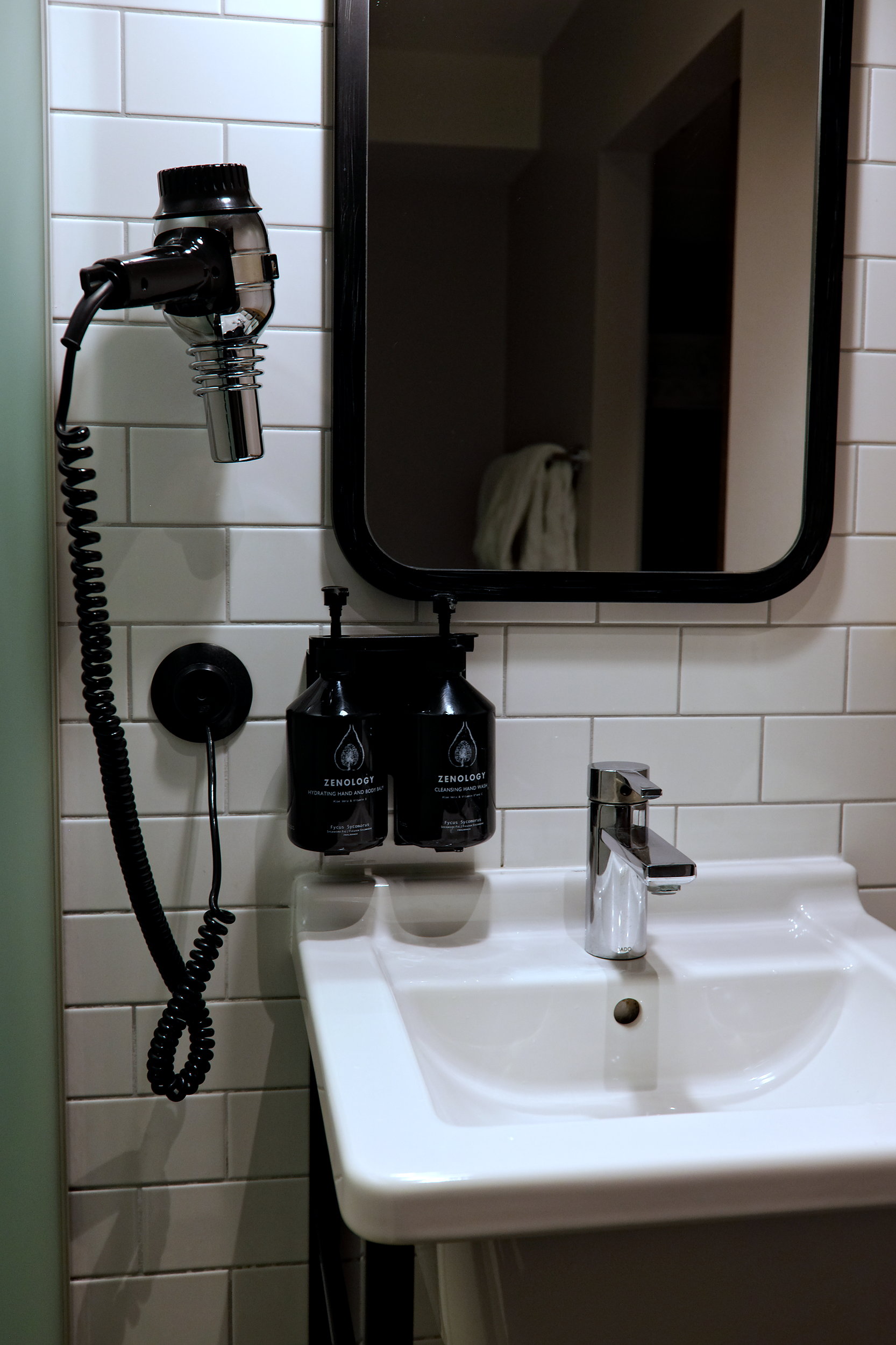 A sink with body products and a desk with window and chair