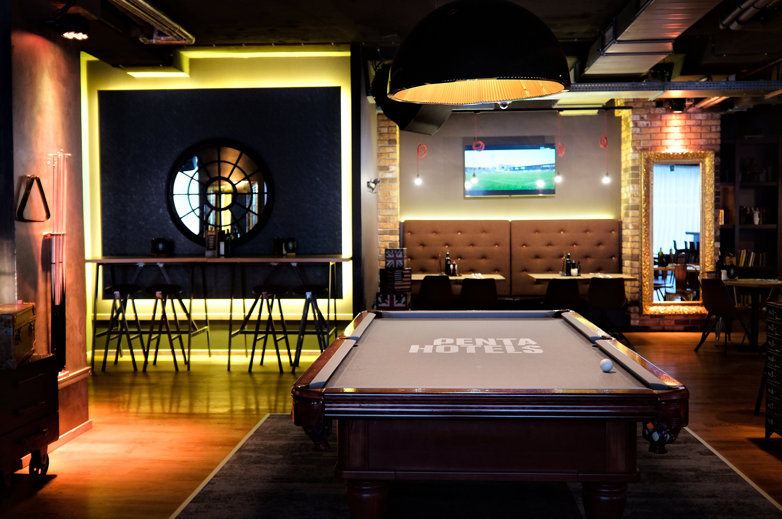 A pool table, lounge chairs, and dining area at Pentahotel Prague