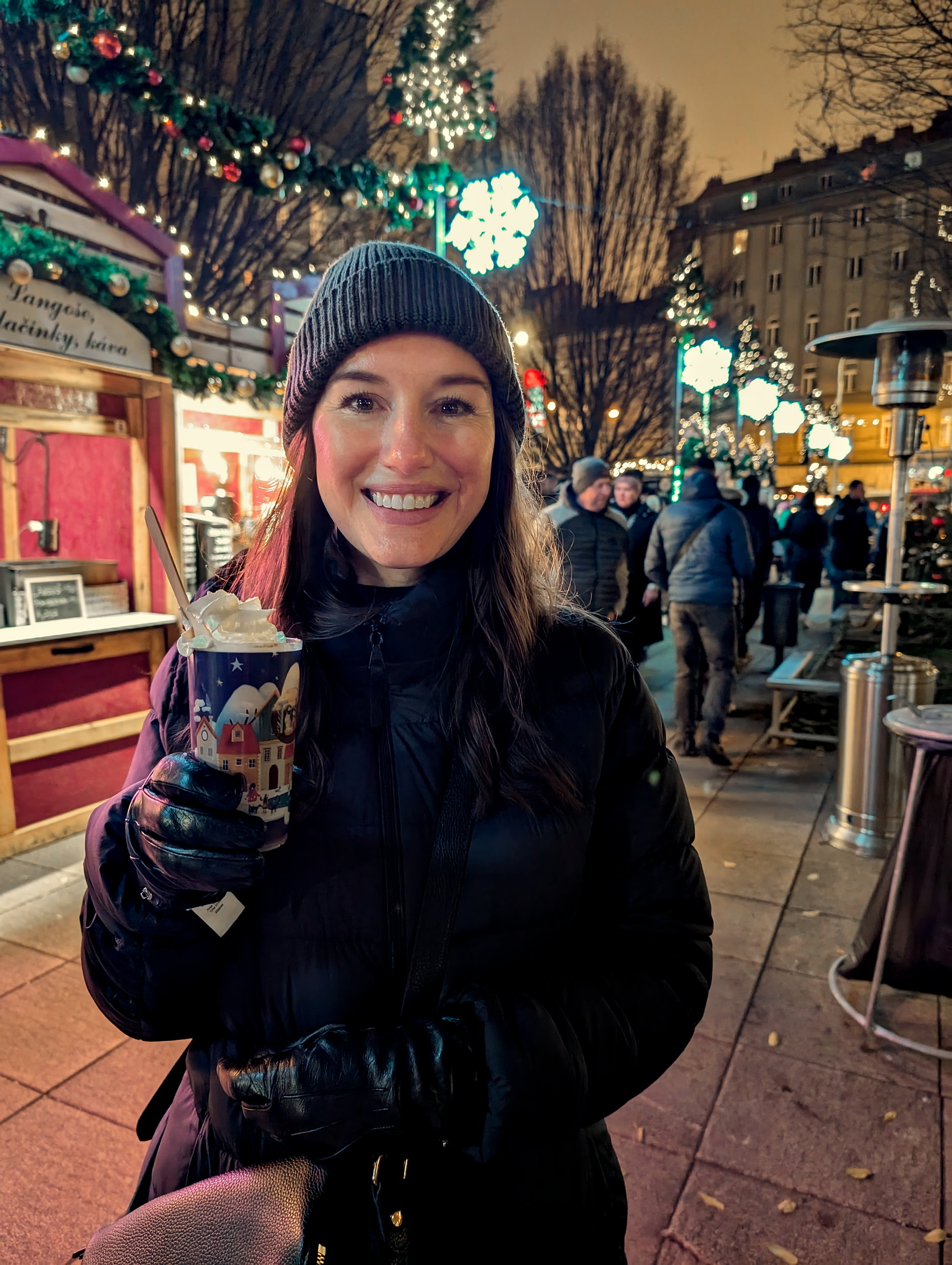 Alyssa holds a plastic cup with a rum beverage topped with whipped cream