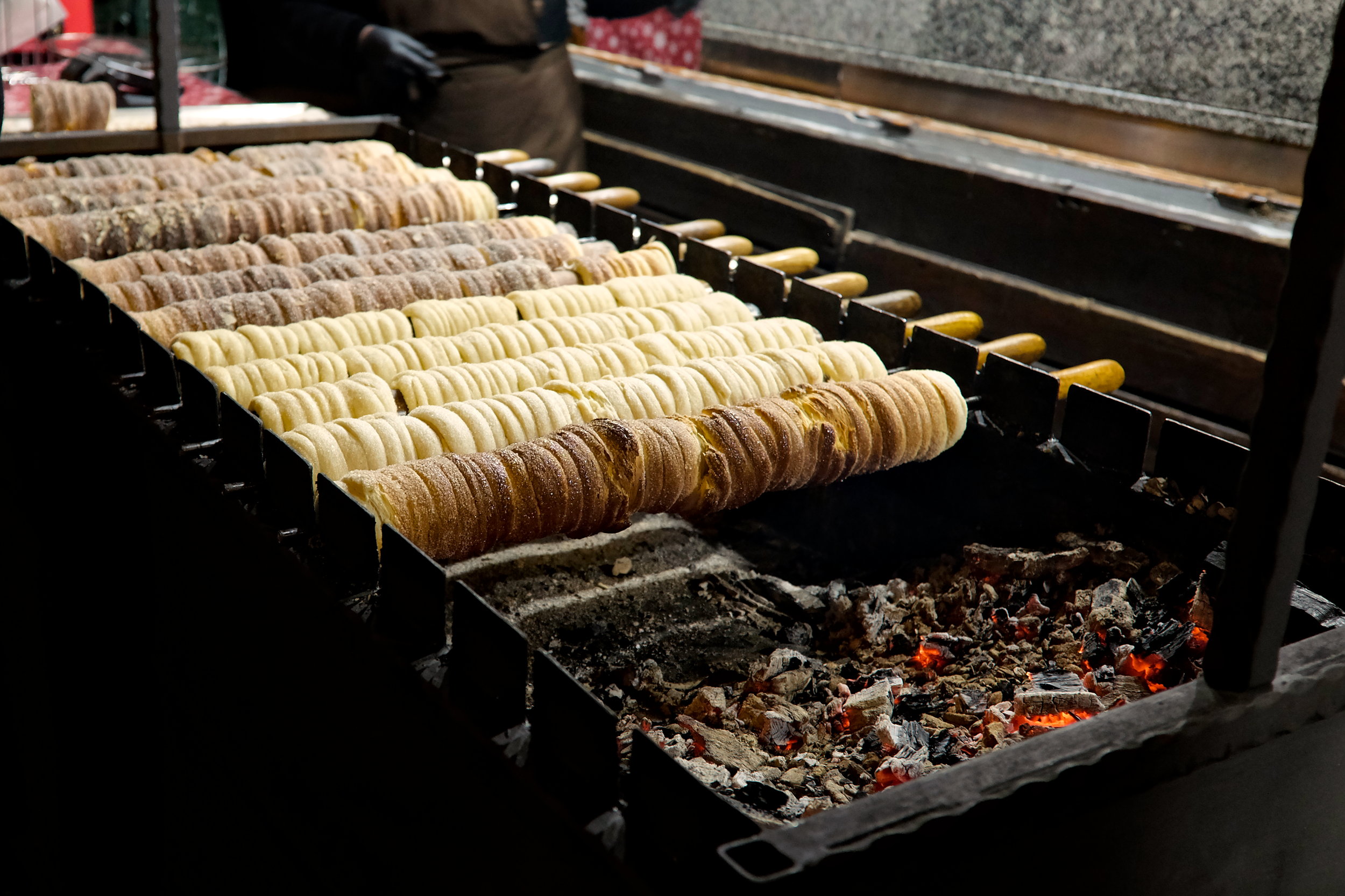 Trdelník rotate over coals at a Christmas market